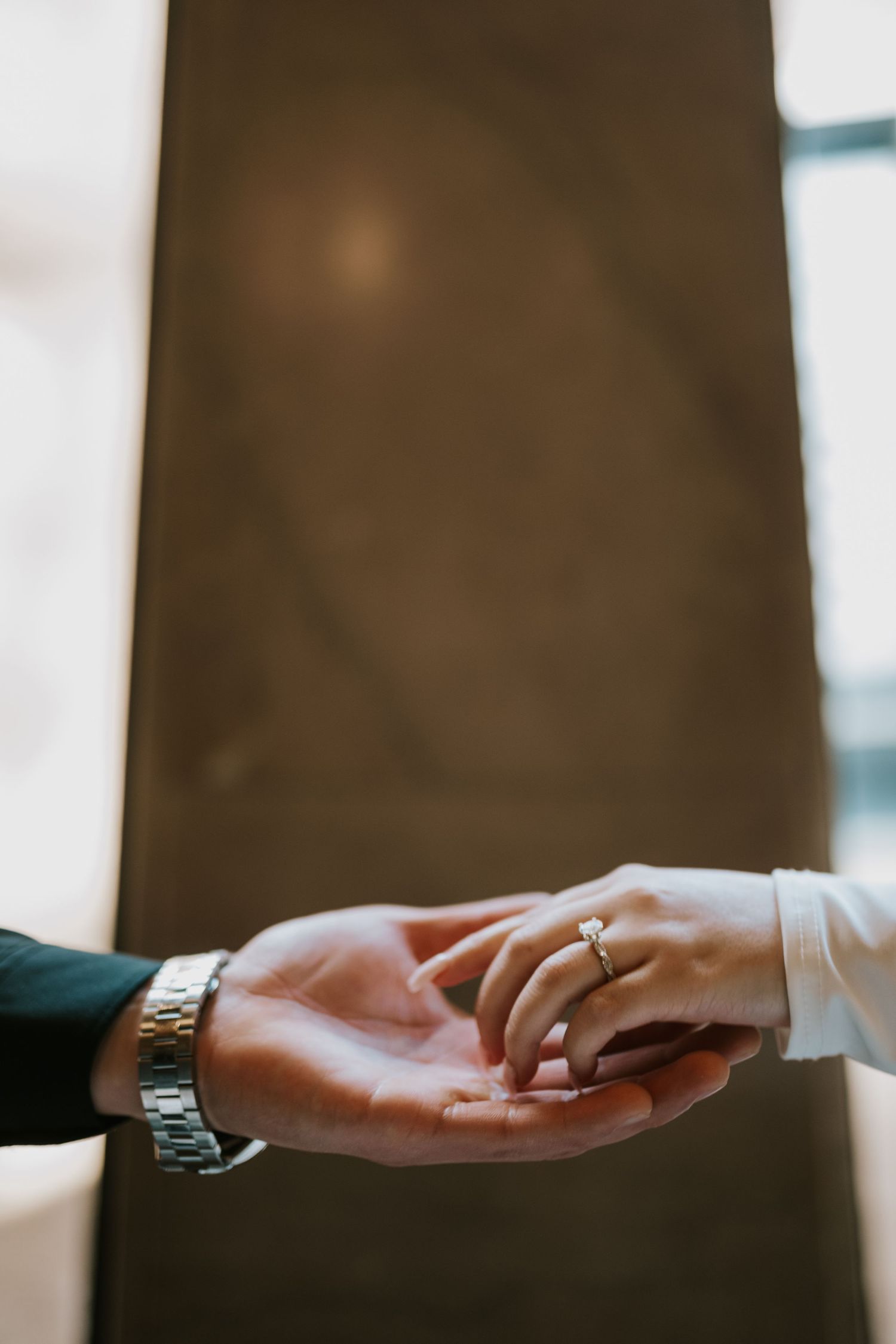 Close-up of hands exchanging rings during an intimate wedding ceremony.