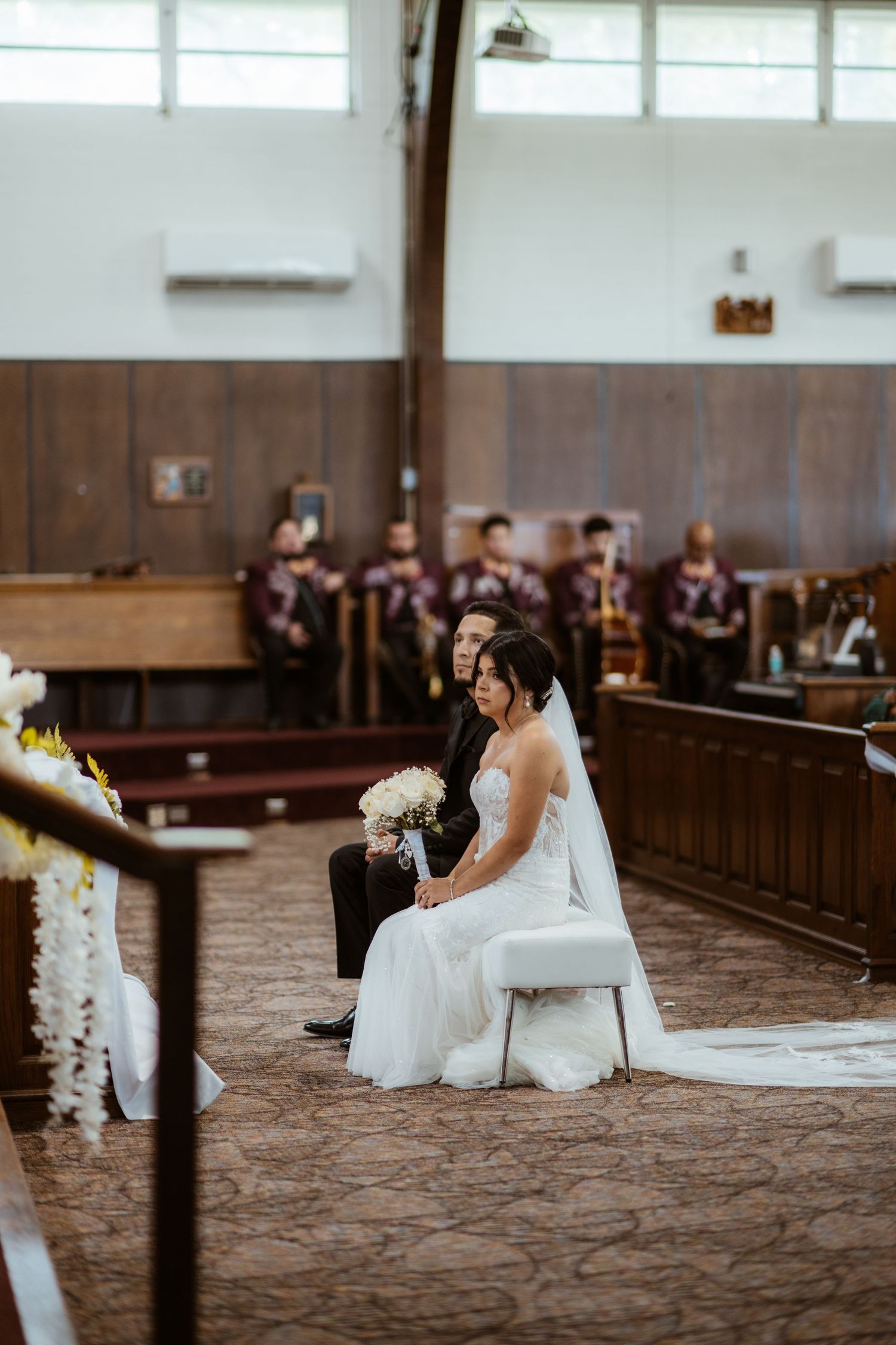 Wedding ceremony setup in traditional church with carpeted aisle and wooden pews.