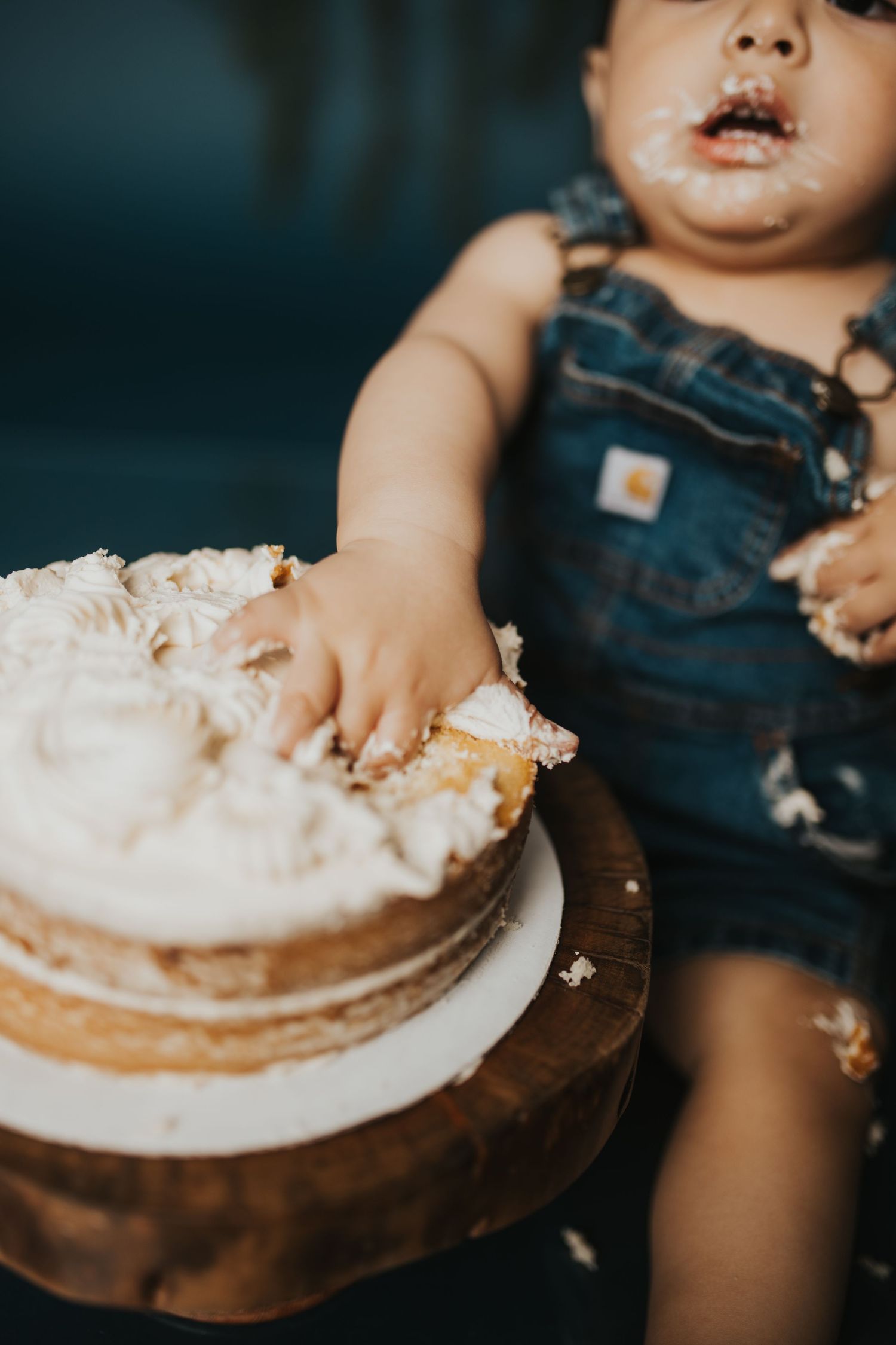Close-up view of a smashed cake on wooden surface during a celebration.