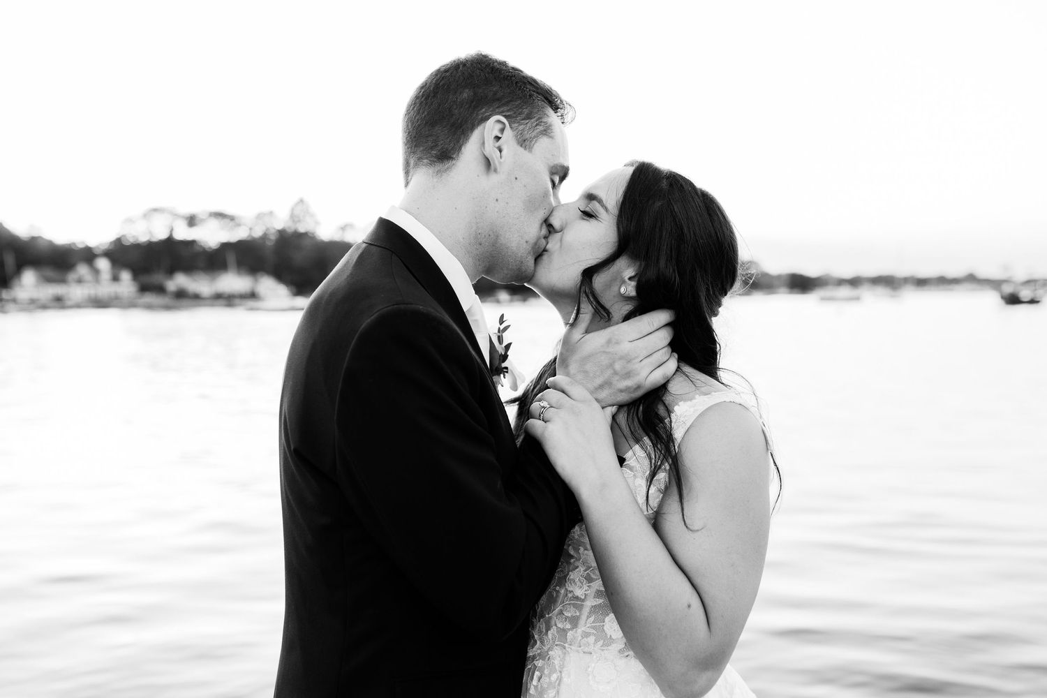 Romantic beachside wedding moment with ocean waves in the background.