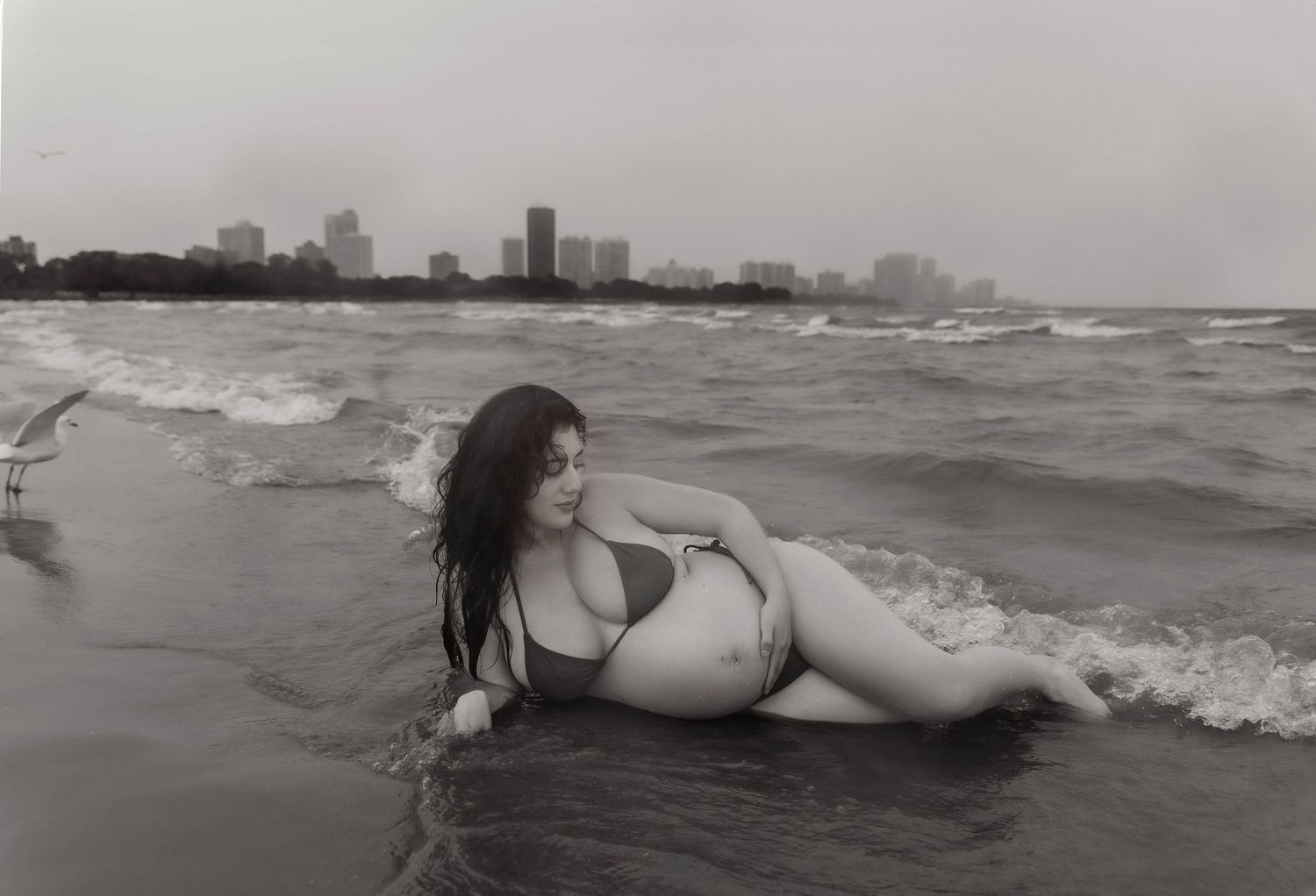 Beach Swim maternity session on overcast day on Montrose Beach in Chicago, IL