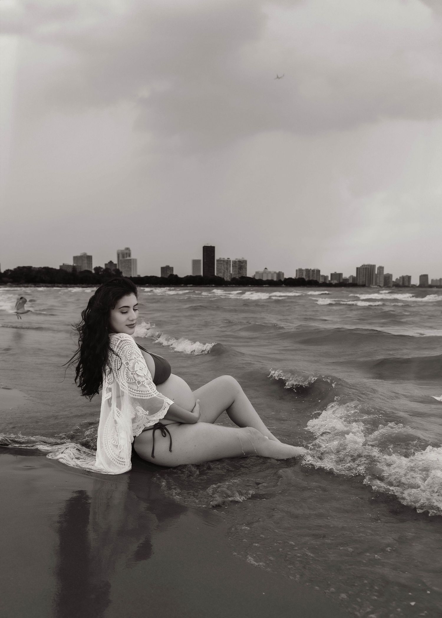 Beach Swim maternity session on overcast day on Montrose Beach in Chicago, IL