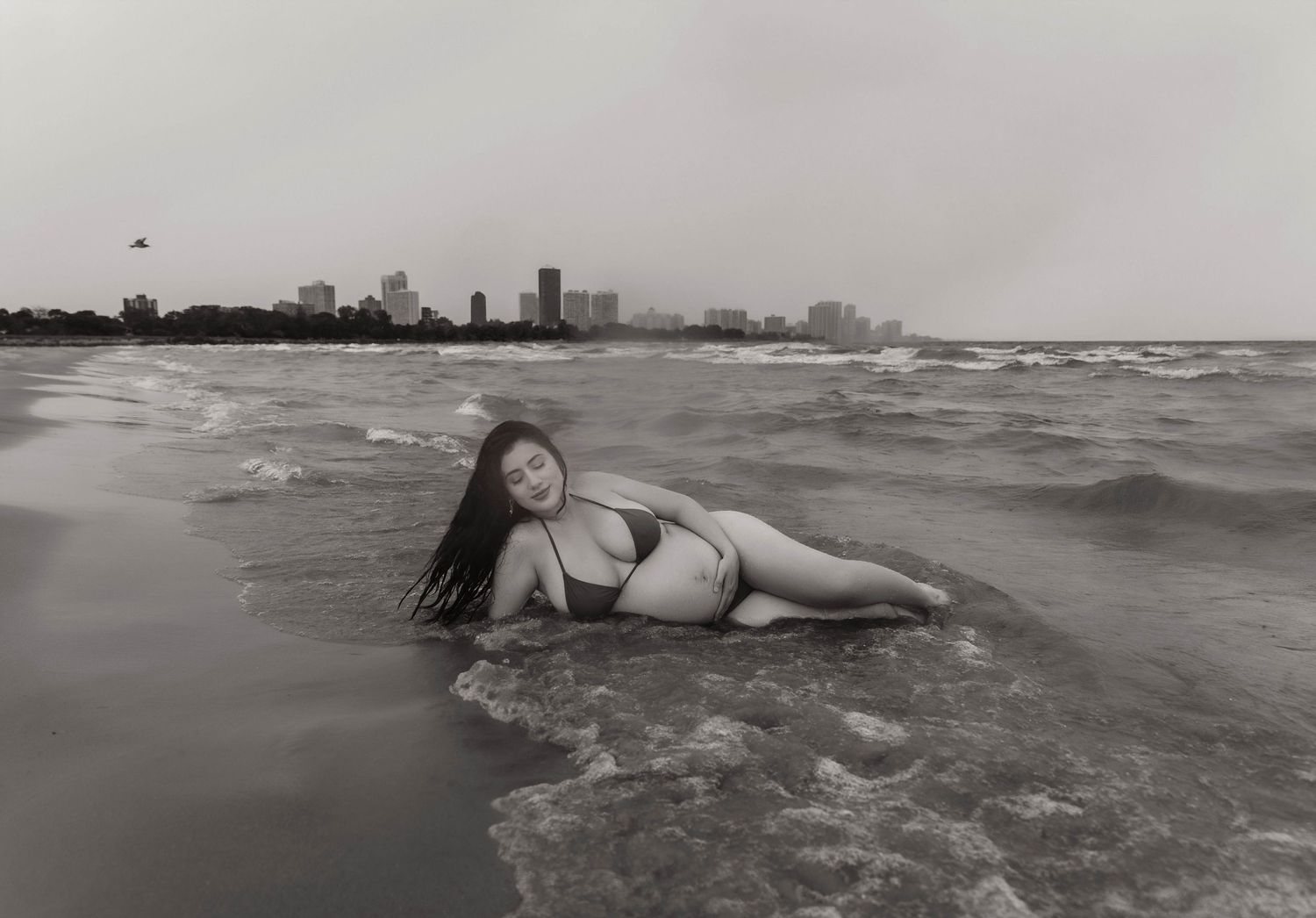 Beach Swim maternity session on overcast day on Montrose Beach in Chicago, IL