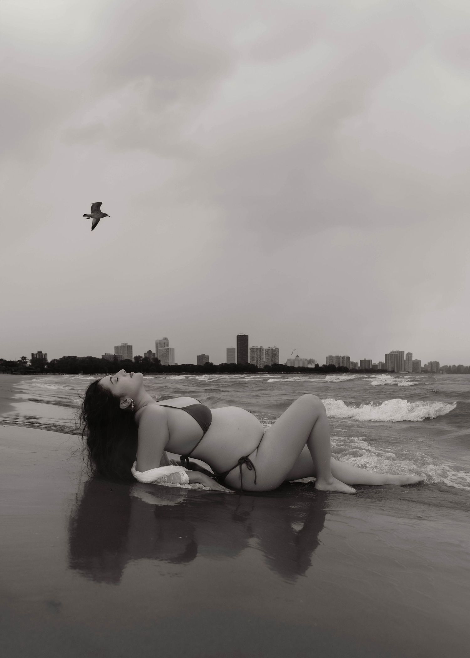 Beach Swim maternity session on overcast day on Montrose Beach in Chicago, IL