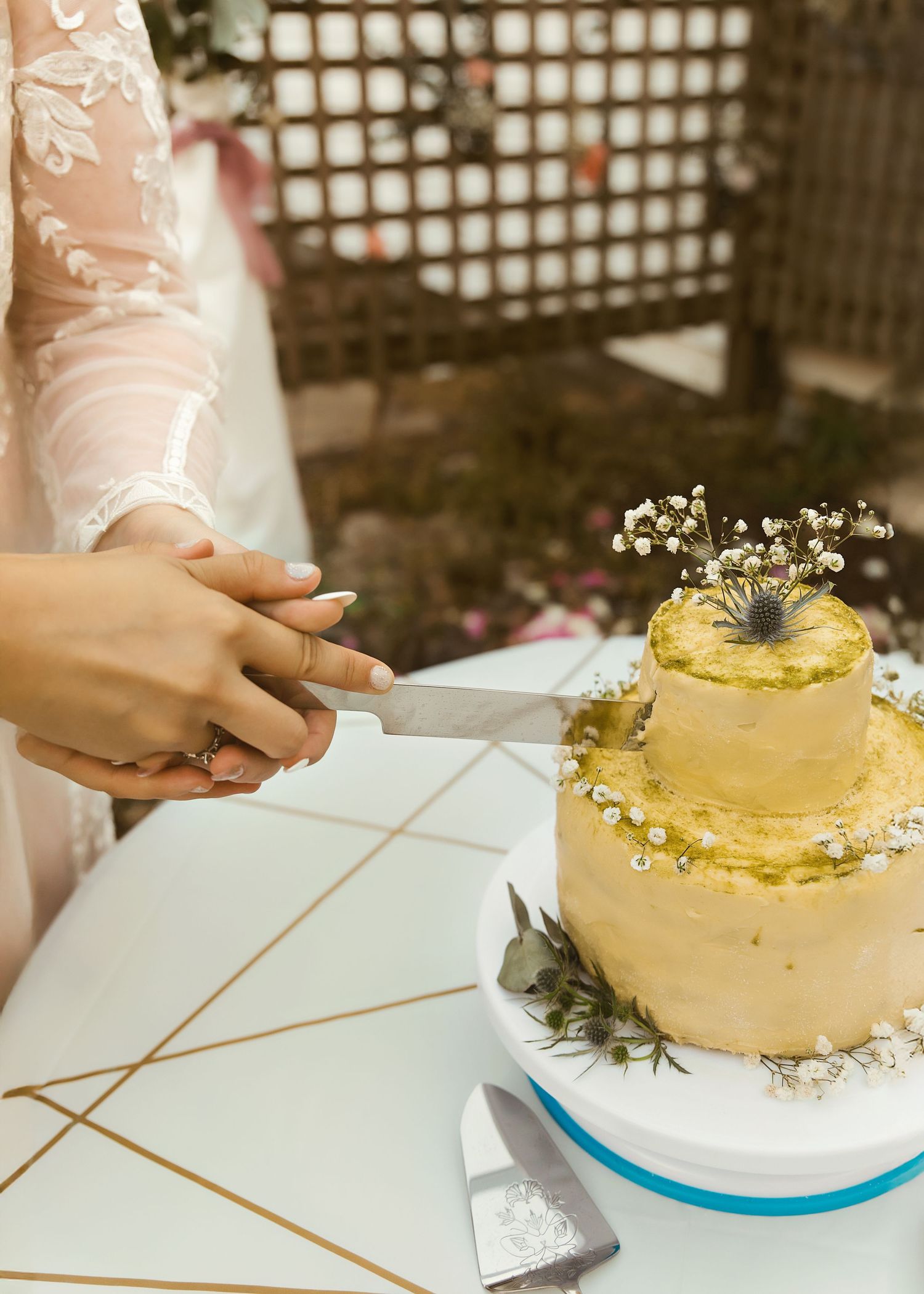 Cake cutting photo with homemade cake including flowers during backyard micro-wedding
