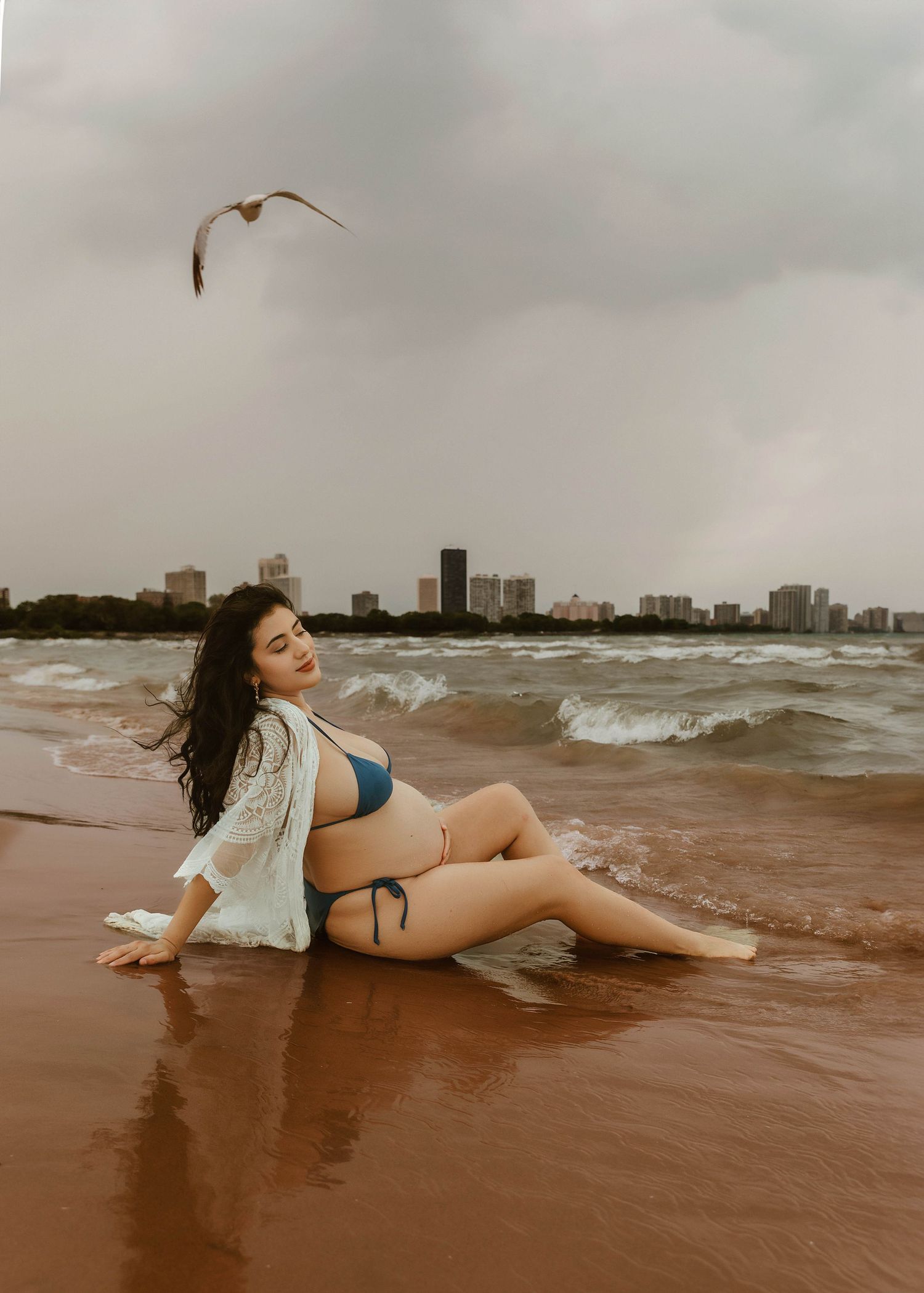 Beach Swim maternity session on overcast day on Montrose Beach in Chicago, IL