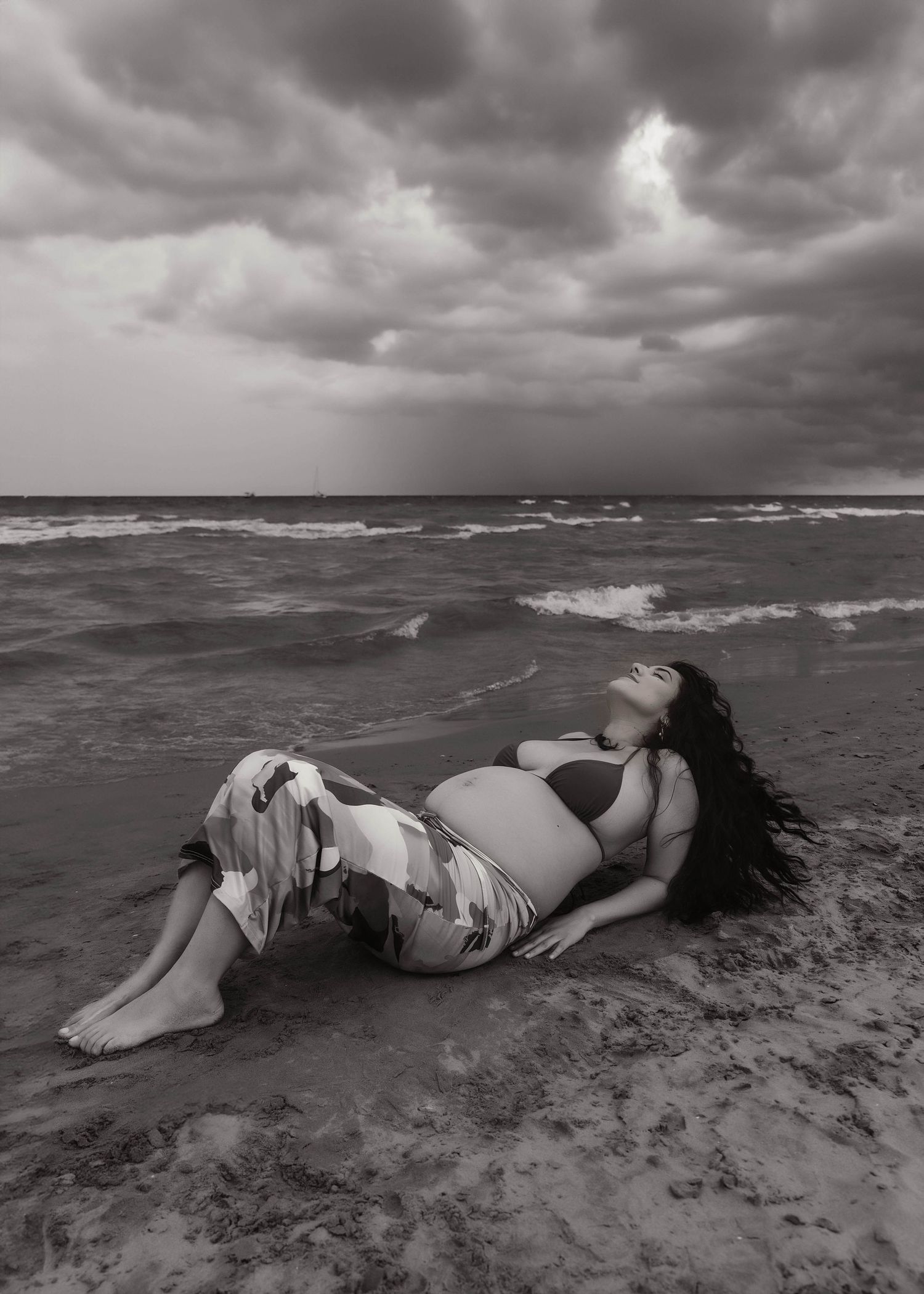 Beach Swim maternity session on overcast day on Montrose Beach in Chicago, IL