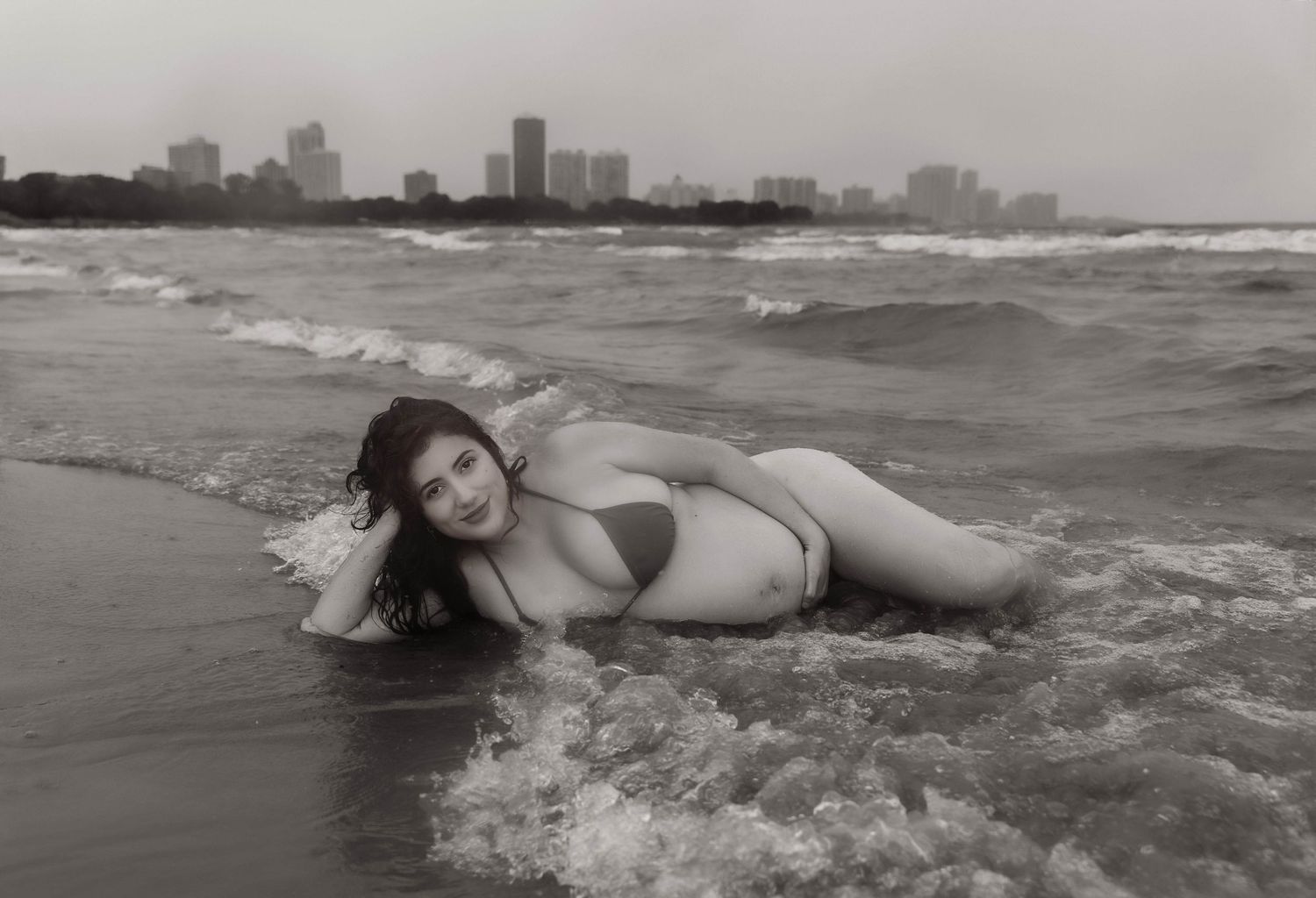 Beach Swim maternity session on overcast day on Montrose Beach in Chicago, IL