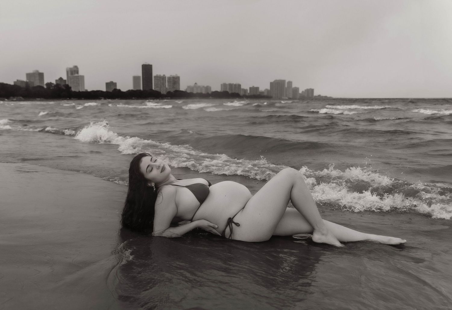 Beach Swim maternity session on overcast day on Montrose Beach in Chicago, IL