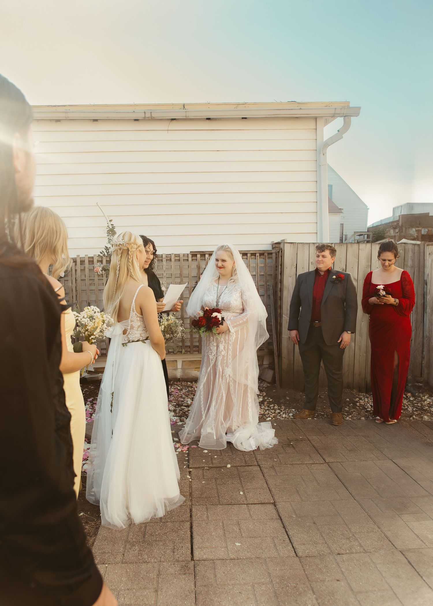 Backyard micro-wedding photo during vows and LGBTQ+ couple
