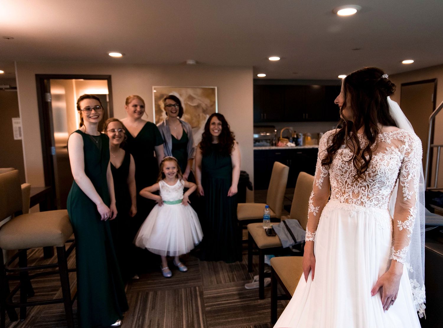 First look photo with wedding party in the hotel room before full wedding