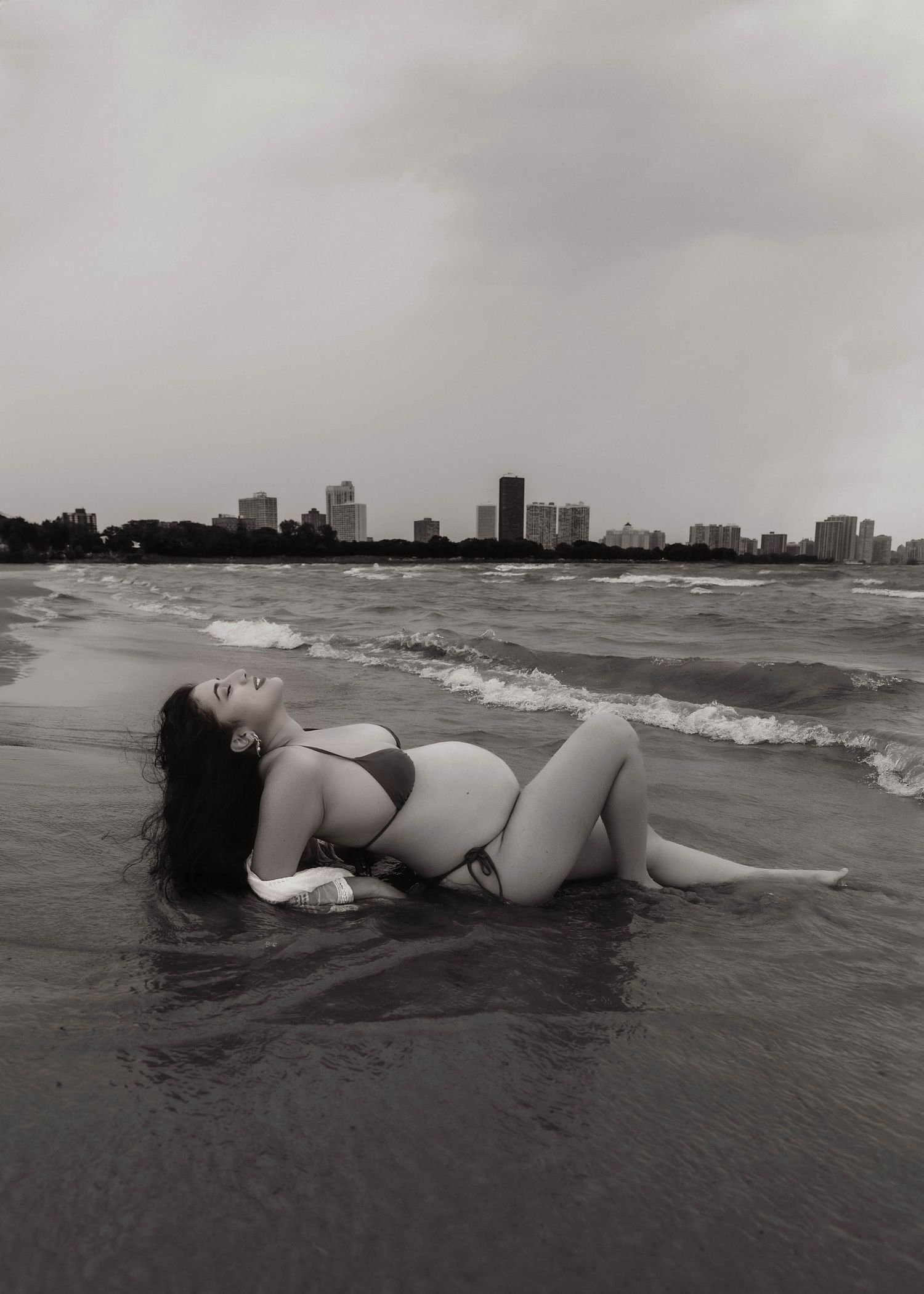 Beach Swim maternity session on overcast day on Montrose Beach in Chicago, IL