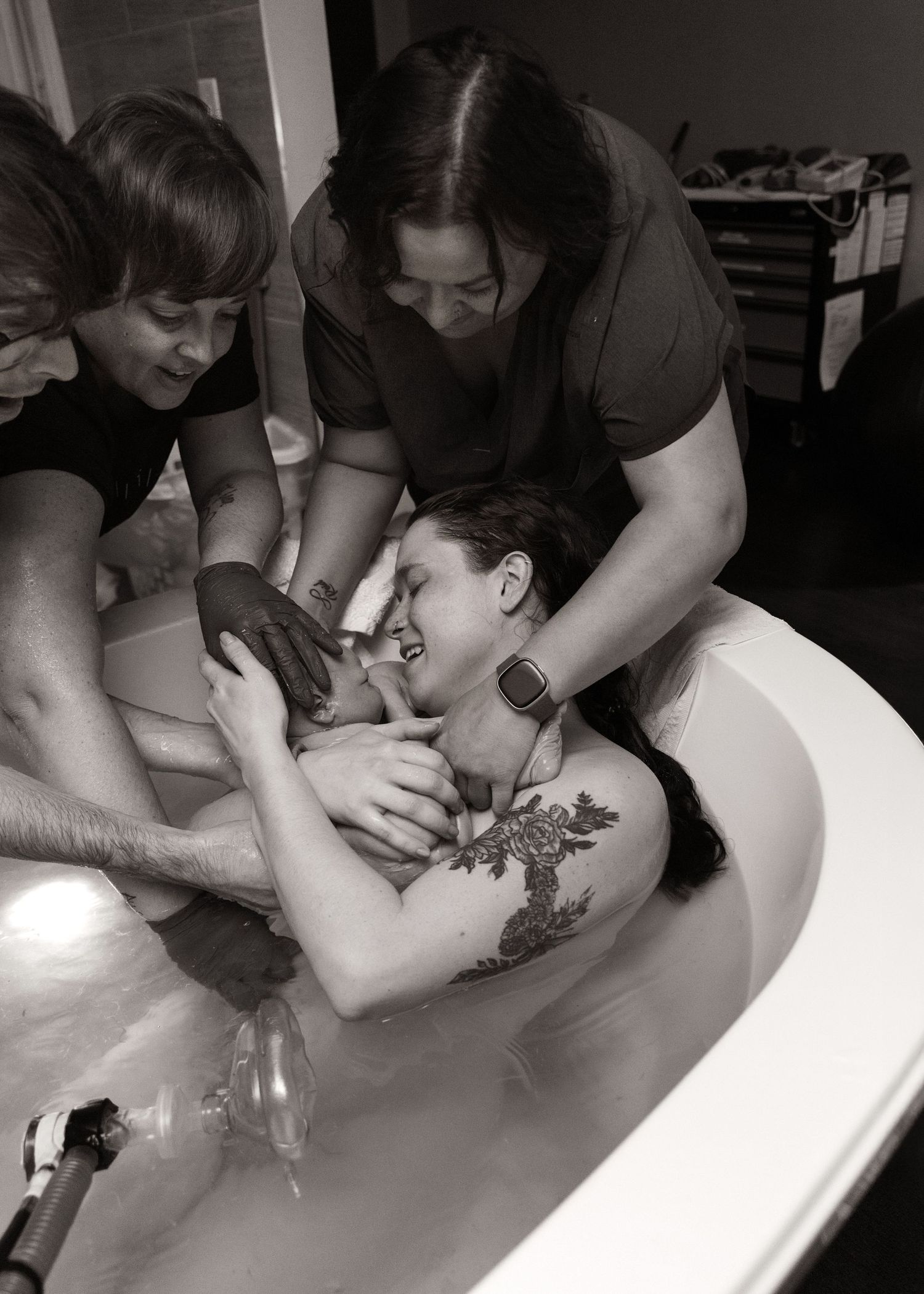 The moment you get to hold your baby for the first time. Birth Photography in tub in Bloomington, IL
