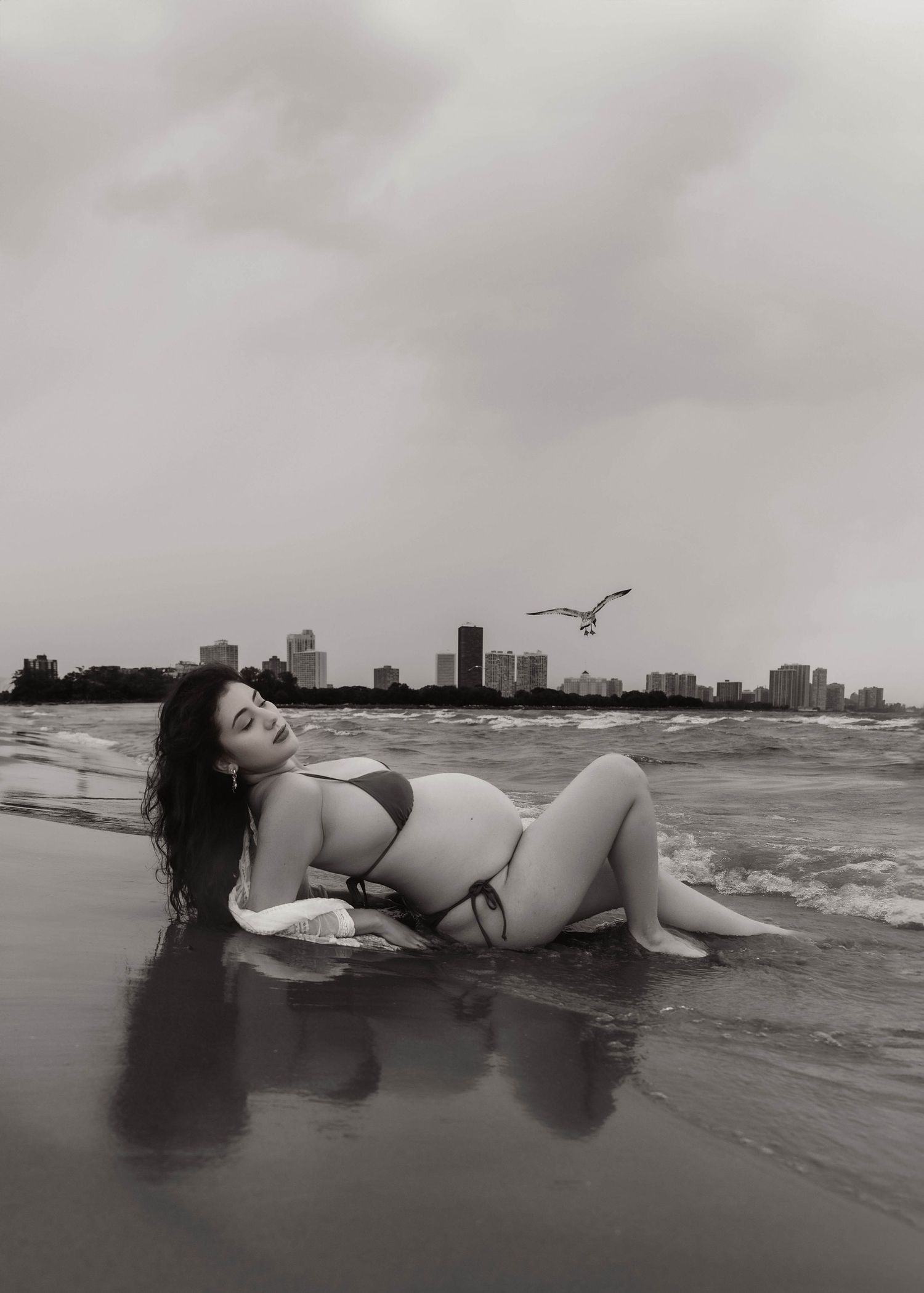 Beach Swim maternity session on overcast day on Montrose Beach in Chicago, IL