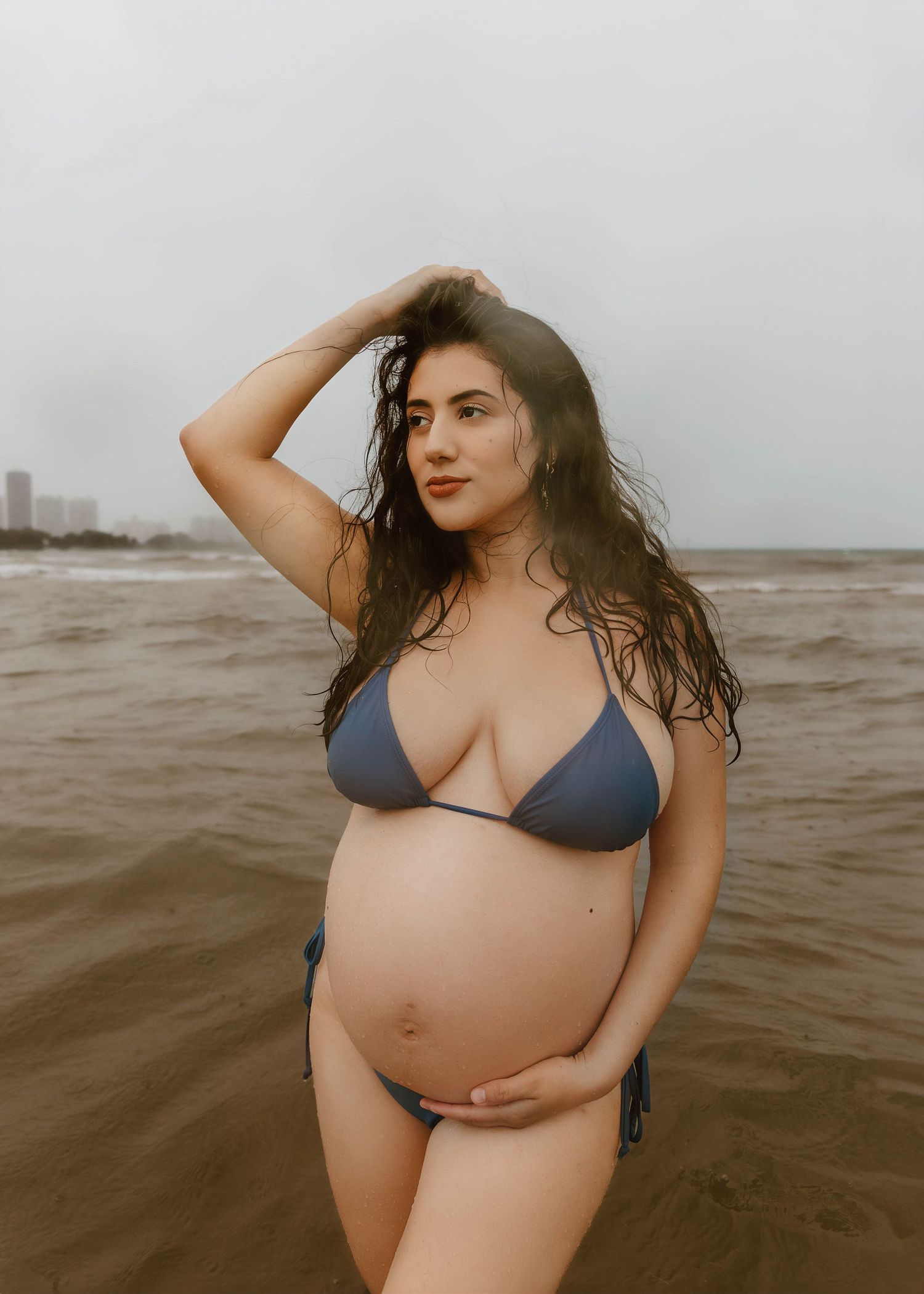 Beach Swim maternity session on overcast day on Montrose Beach in Chicago, IL