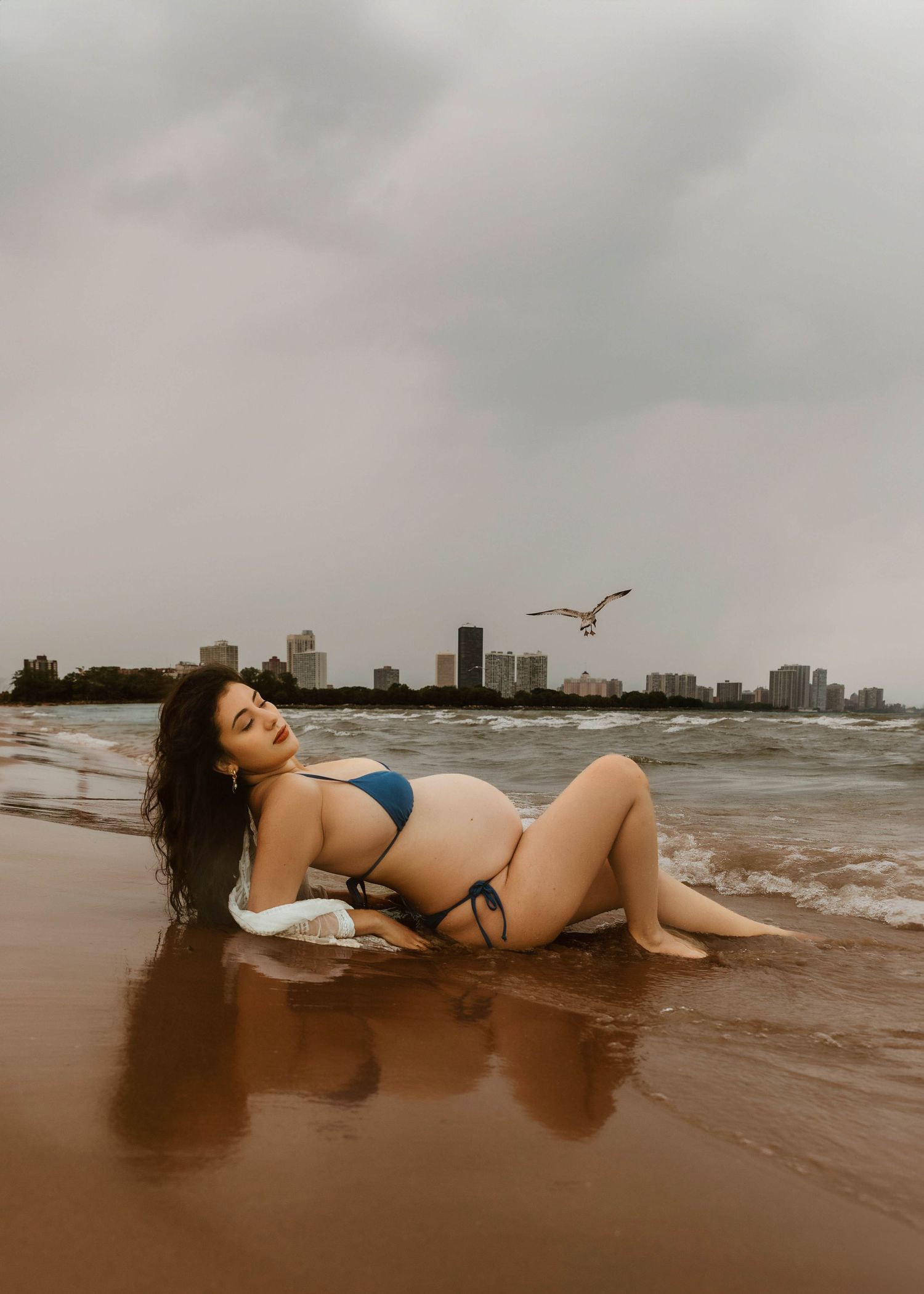 Beach Swim maternity session on overcast day on Montrose Beach in Chicago, IL