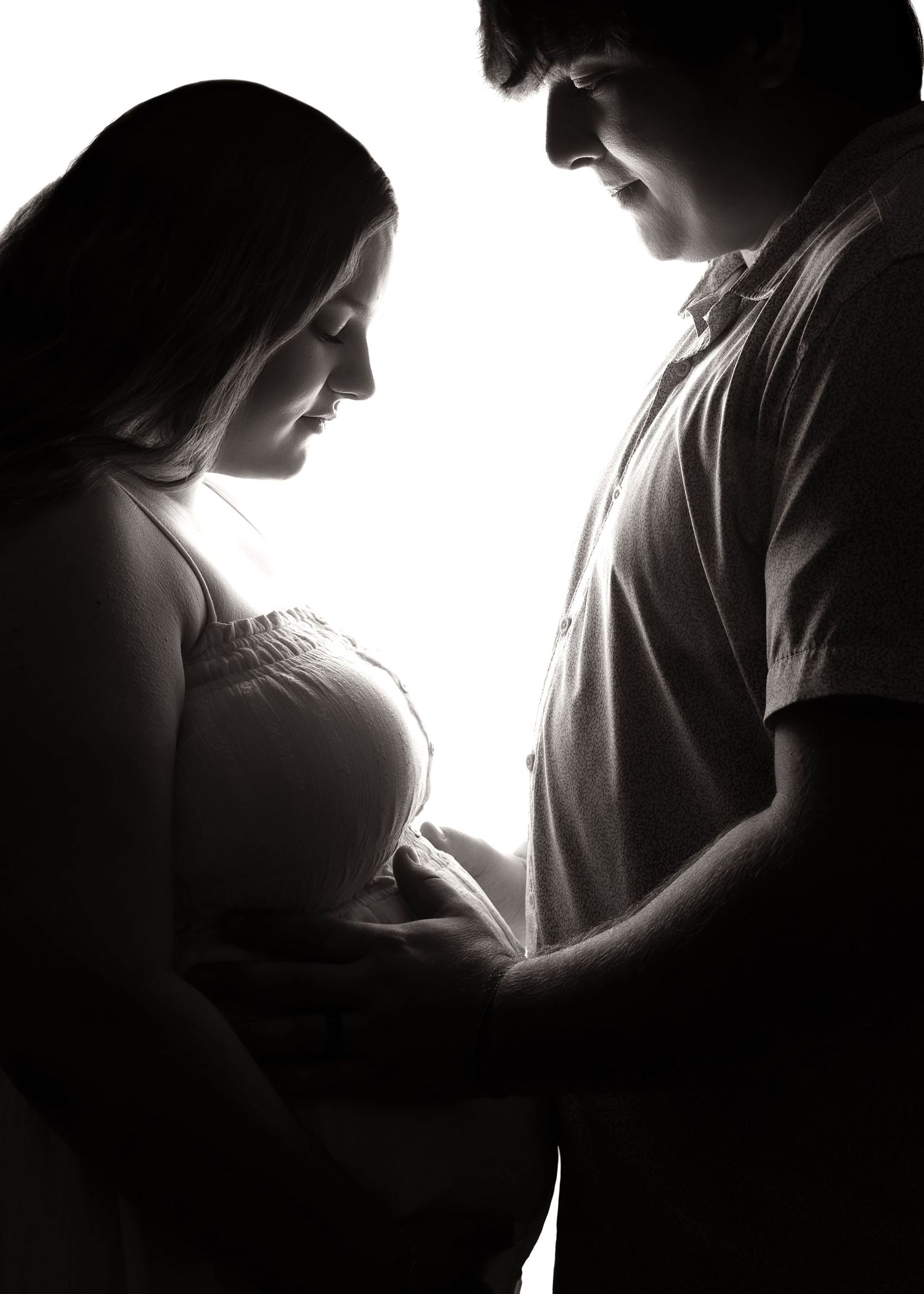 In-studio, backlit maternity session with mom and dad in Peoria, IL