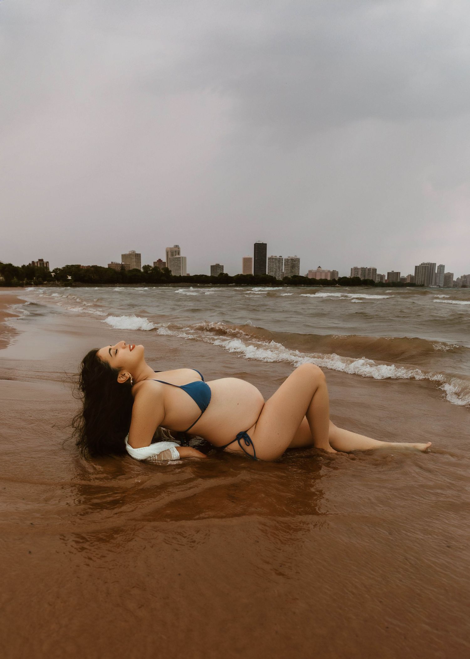 Beach Swim maternity session on overcast day on Montrose Beach in Chicago, IL