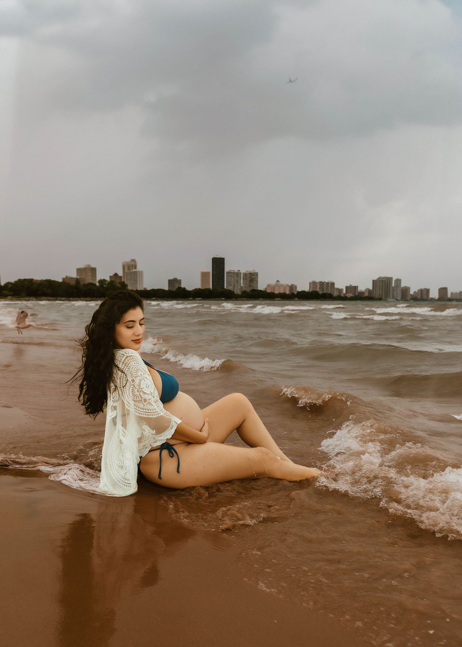 Beach Swim maternity session on overcast day on Montrose Beach in Chicago, IL