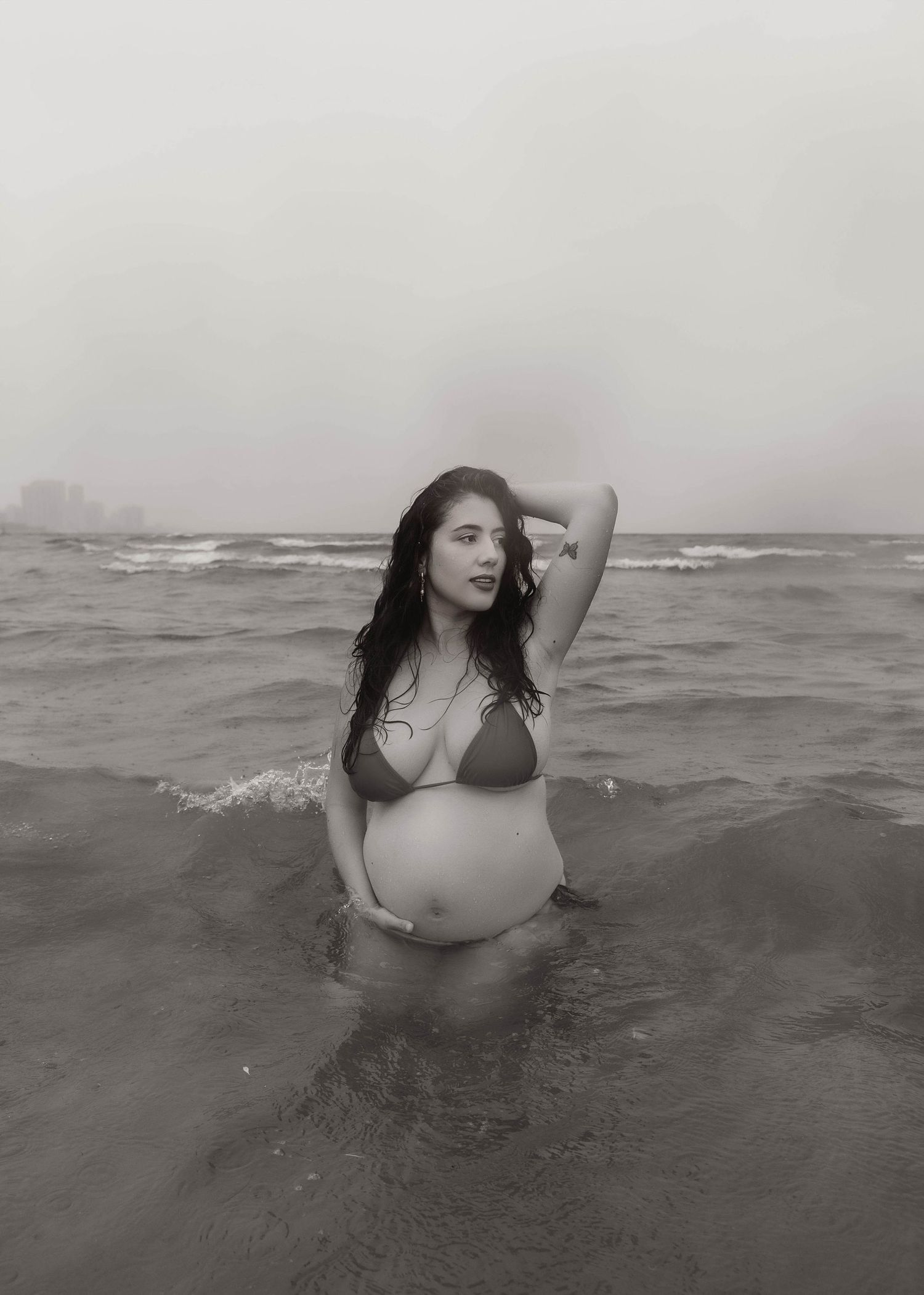 Beach Swim maternity session on overcast day on Montrose Beach in Chicago, IL