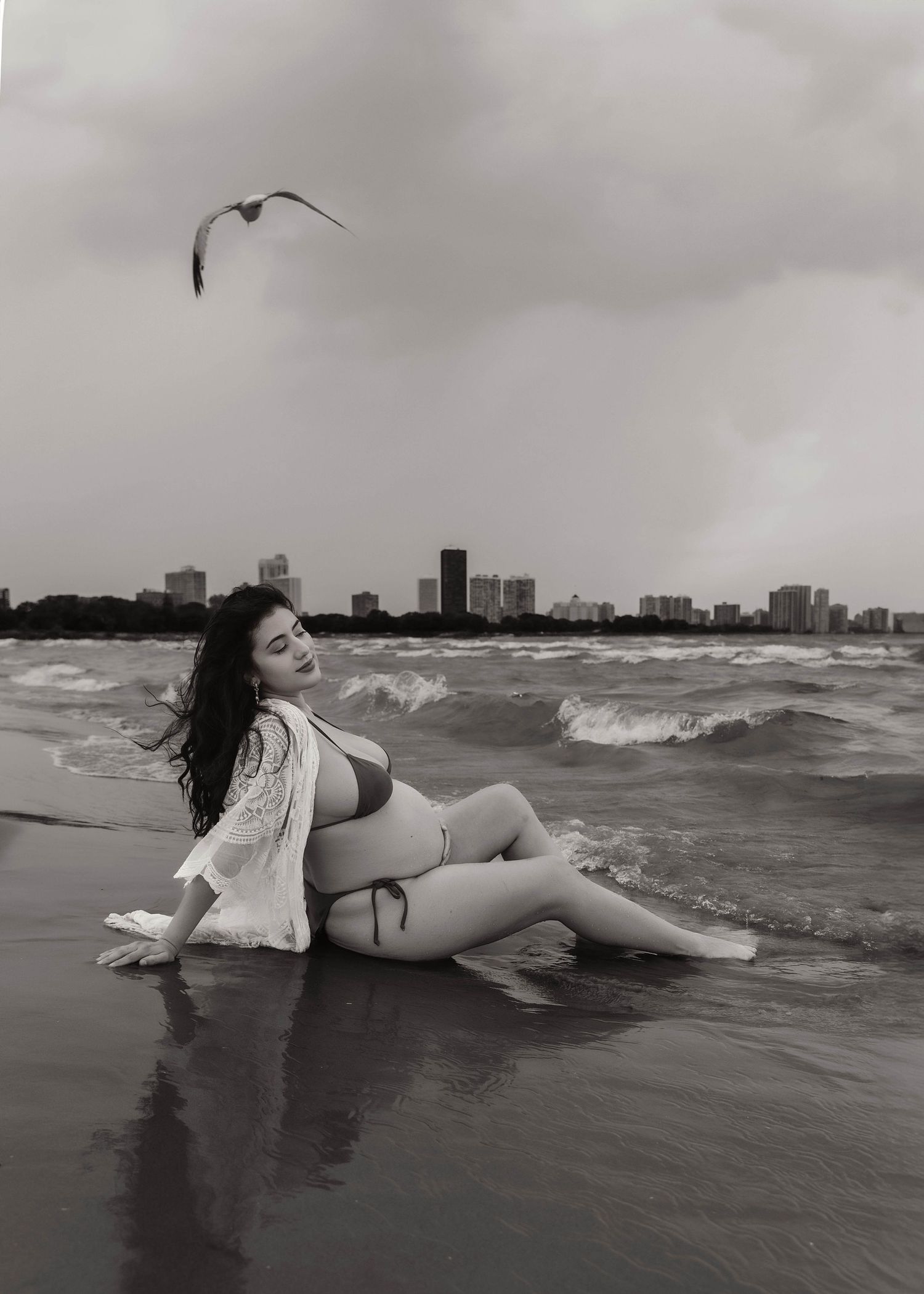 Beach Swim maternity session on overcast day on Montrose Beach in Chicago, IL