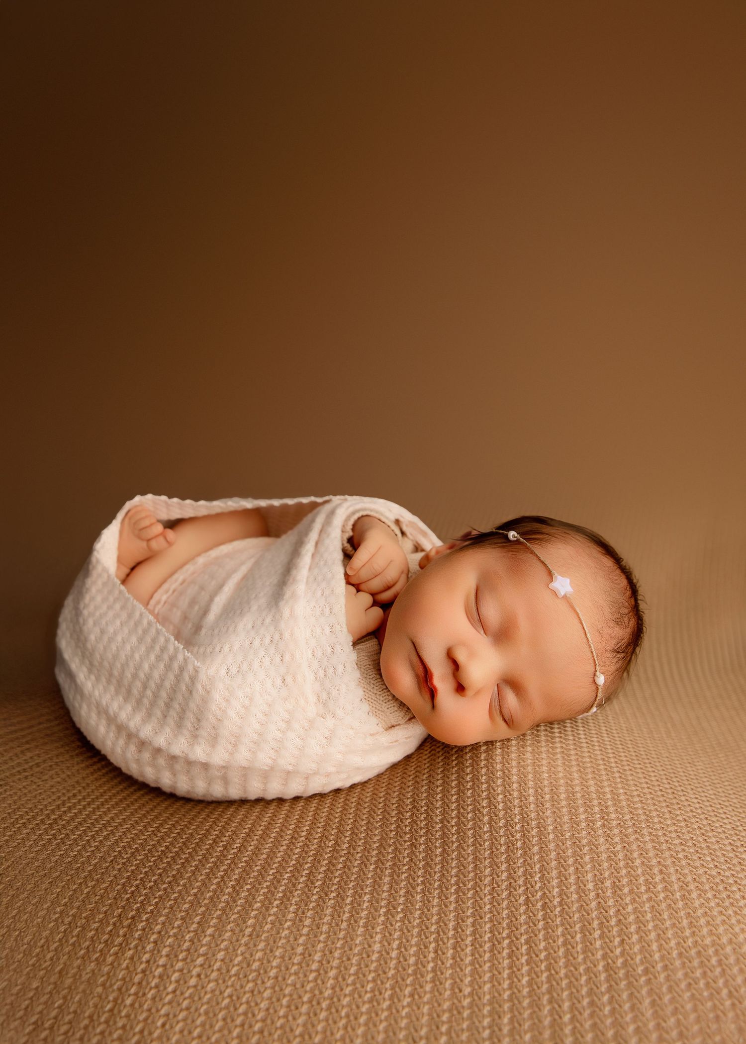 Feet out swaddle of a newborn baby girl with rose tieback and Little Fox & Co backdrop