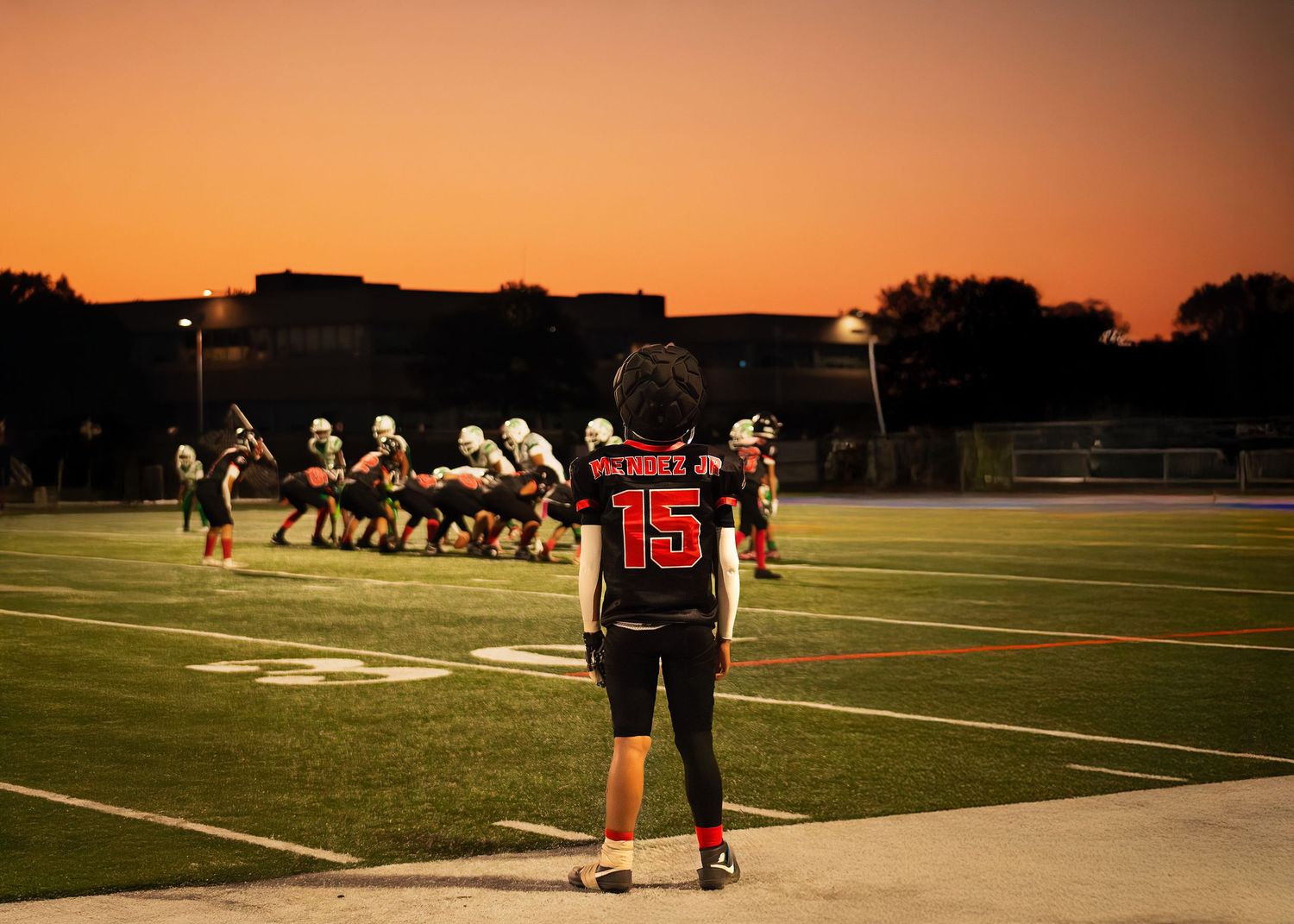 Chicago highschool football action shot on the sidelines during sunset