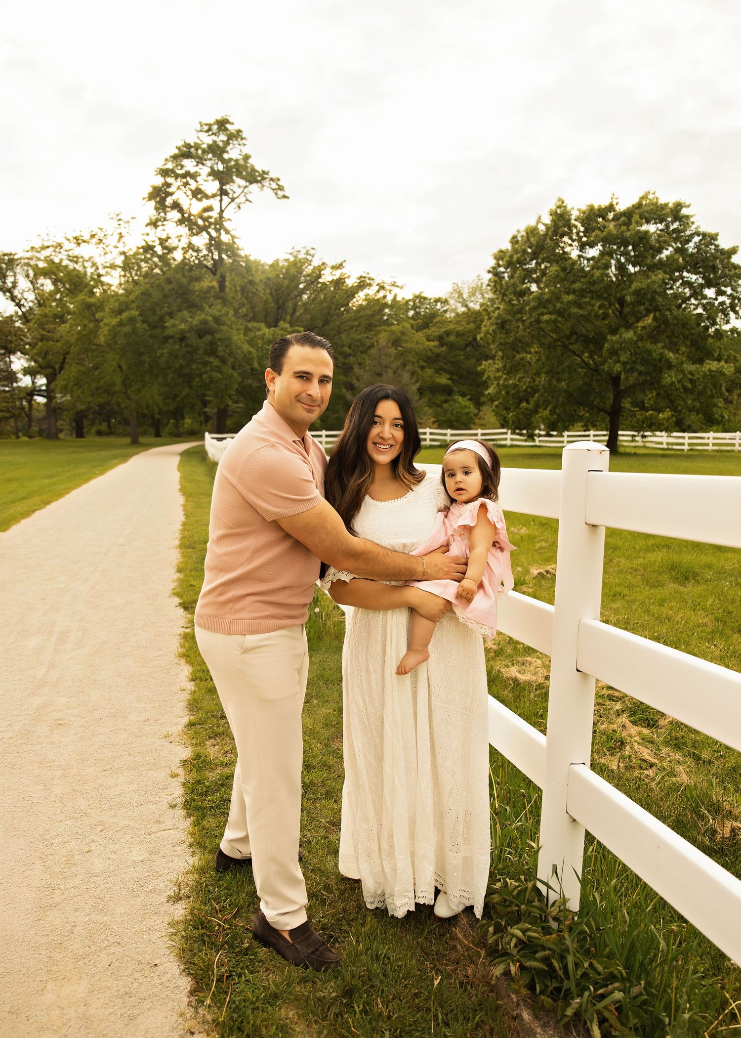 Family photo during 1 year portrait milestone session at St James Farm Forest Preserve with white picket fence and smiles all around