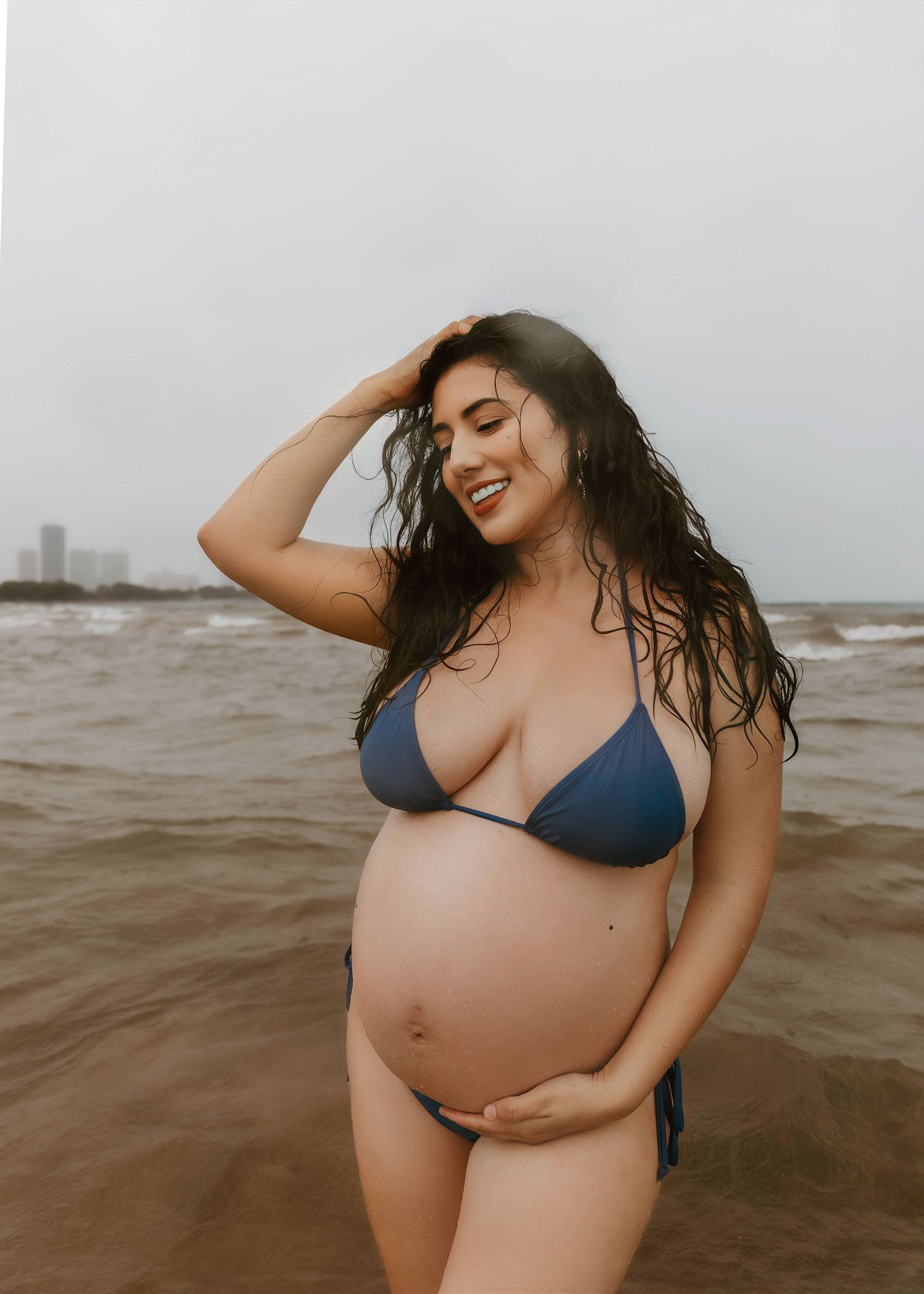 Beach Swim maternity session on overcast day on Montrose Beach in Chicago, IL
