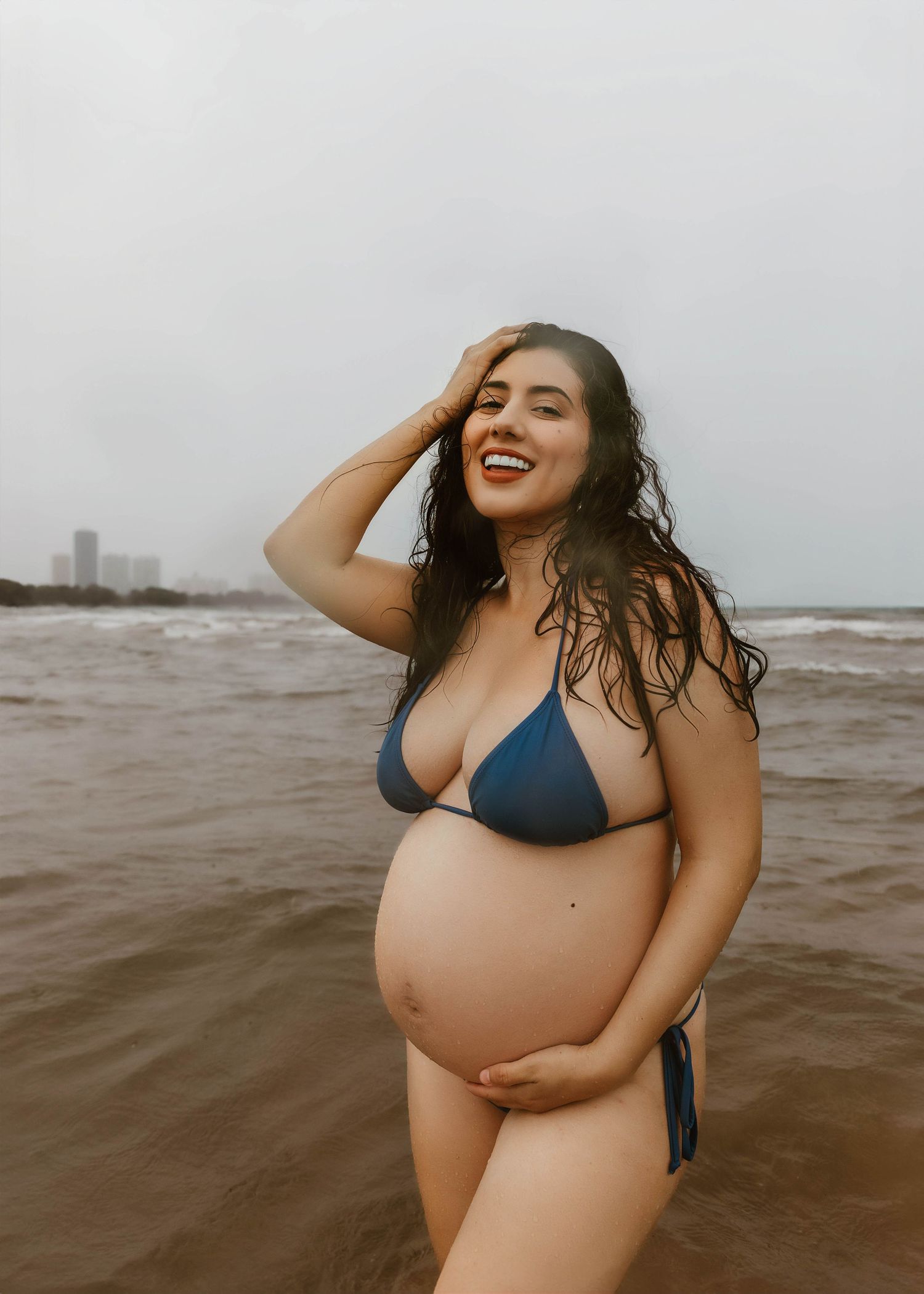 Beach Swim maternity session on overcast day on Montrose Beach in Chicago, IL
