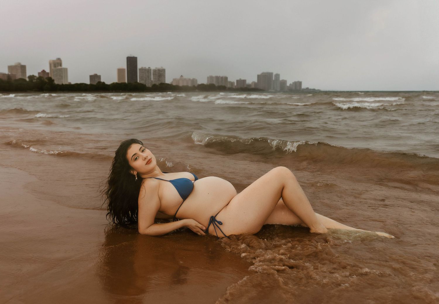 Beach Swim maternity session on overcast day on Montrose Beach in Chicago, IL