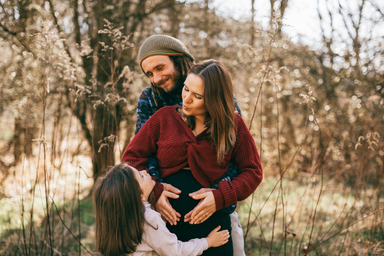 Eine Familie erlebt liebevolle Augenblicke gemeinsam in einem Frühjahres Feld voller getrockneter Pflanzen in Konz.