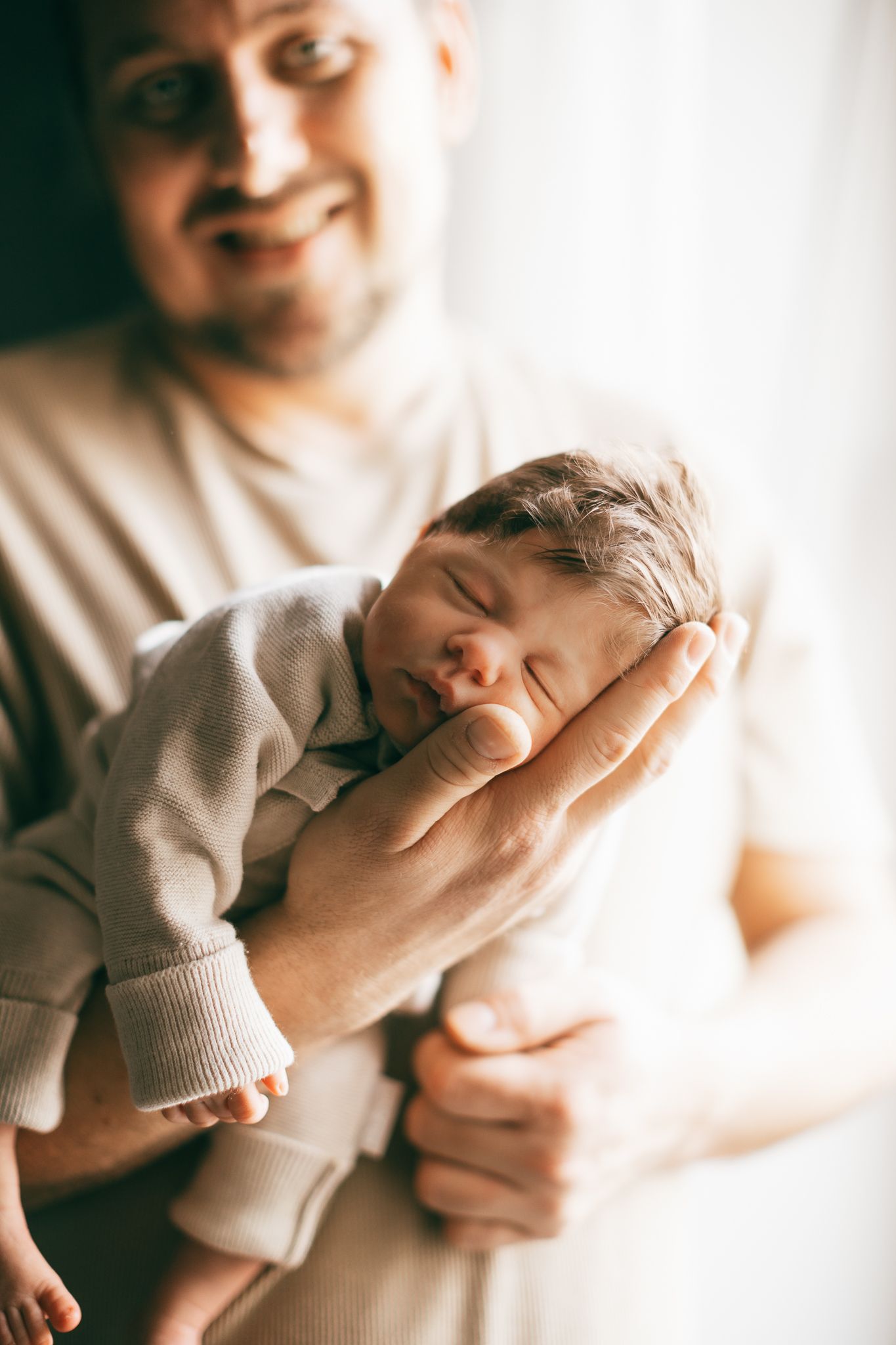 „Ein friedlich schlafendes Baby wird in den Armen seines Papa gehalten.