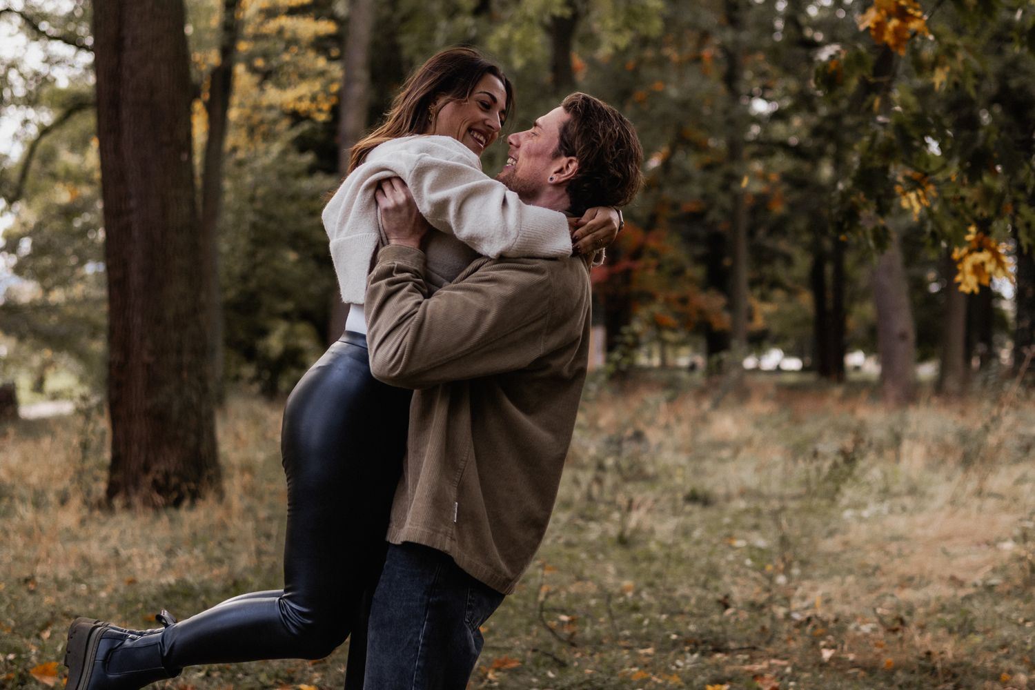 Ein glückliches Paar genießt ausgelassene, verspielte Fotoshootings in einem herbstlich bewaldeten Umfeld in Trier.