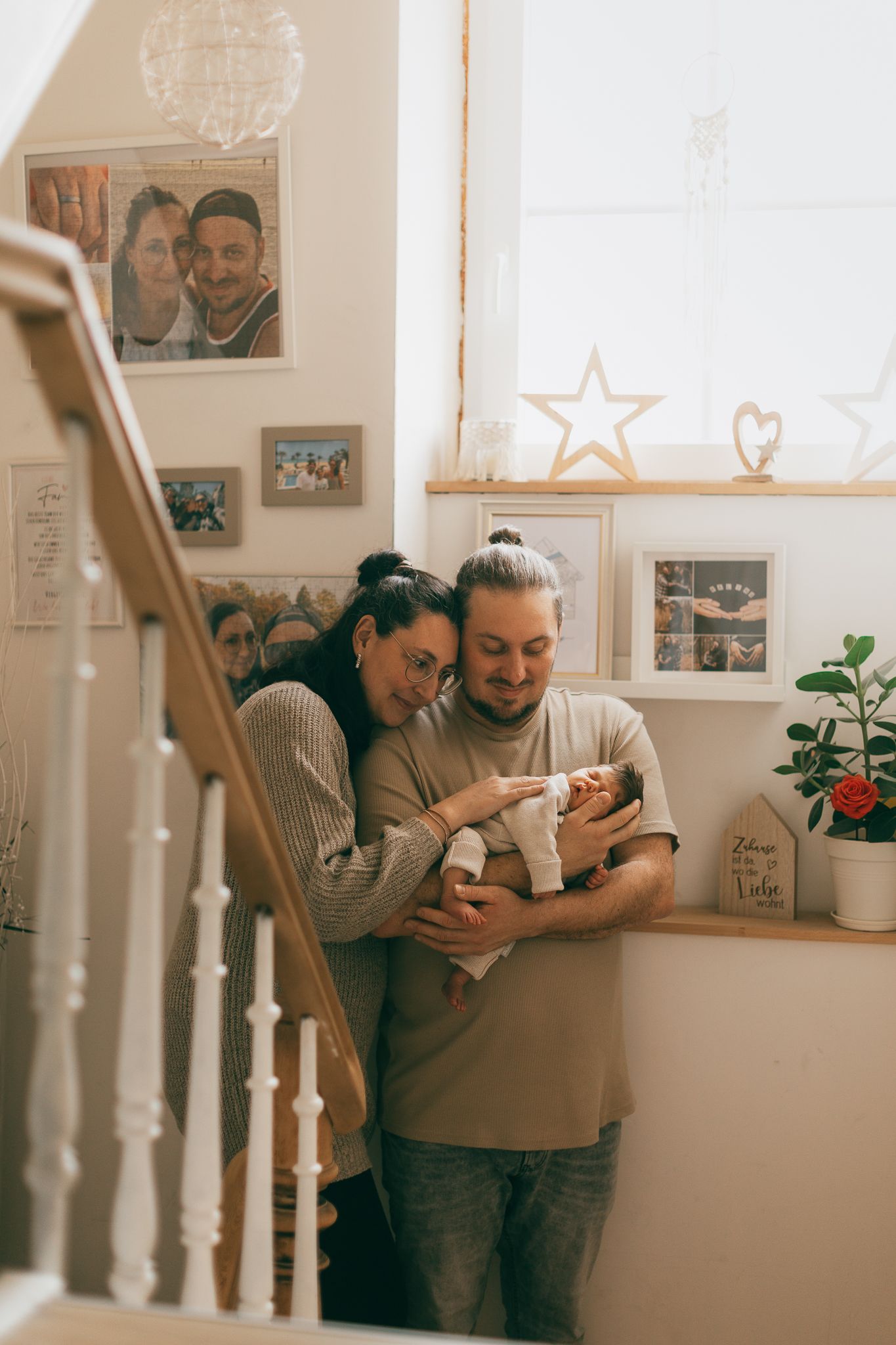 Zwei Personen teilen einen zärtlichen Moment mit ihrem Baby im eigenen Zuhause in Konz.