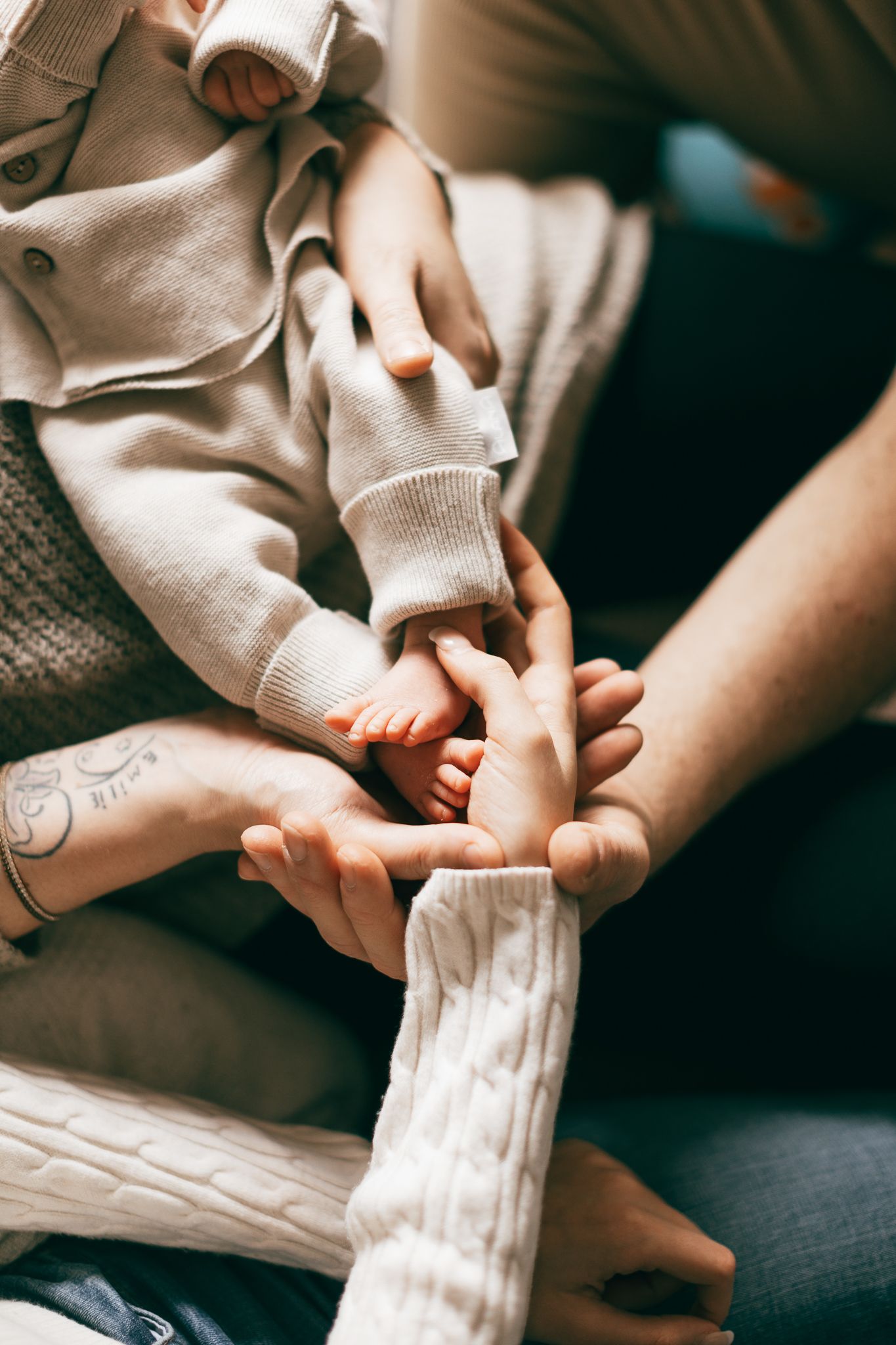 Eine zarte Nahaufnahme von kleinen Babyfüßen, sanft gehalten von liebevollen Händen in Konz.