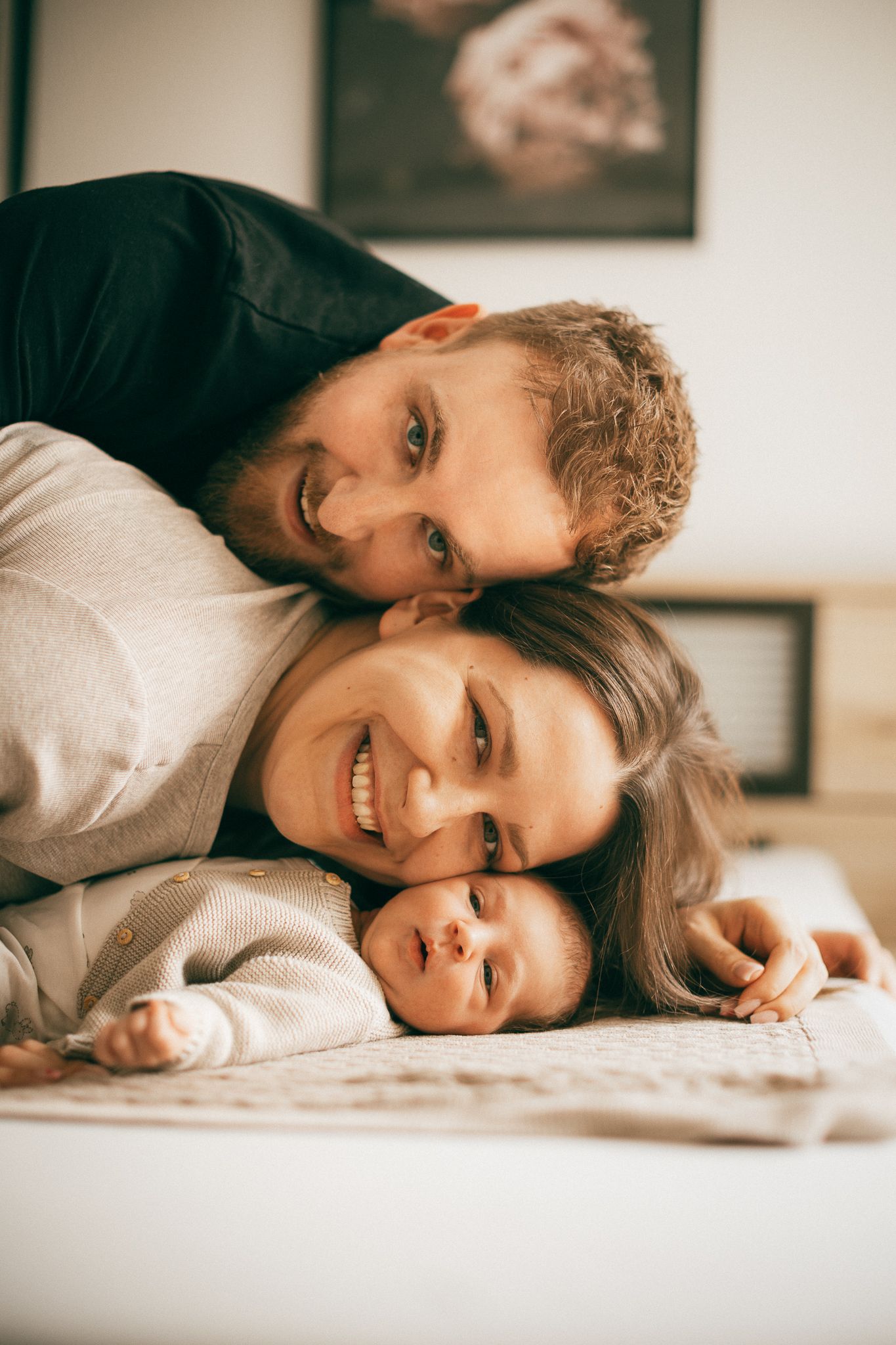 Eine Familie liegt zusammen im Bett und genießt innige Momente im Zuhause in Tawern.