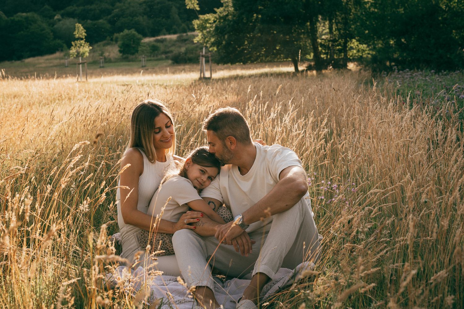 Ein intimer Familienmoment in einem von der Sonne durchfluteten Feld mit goldenem Gras