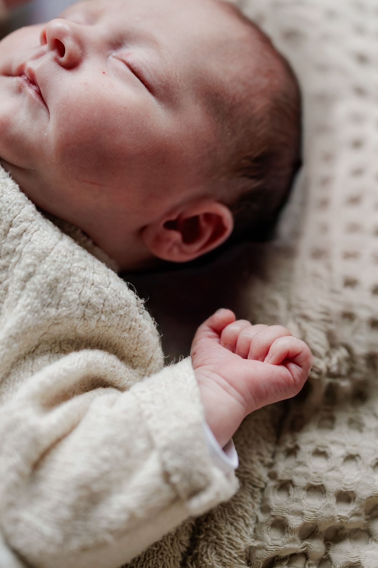 A newborn baby sleeping peacefully, wrapped in a soft blanket.