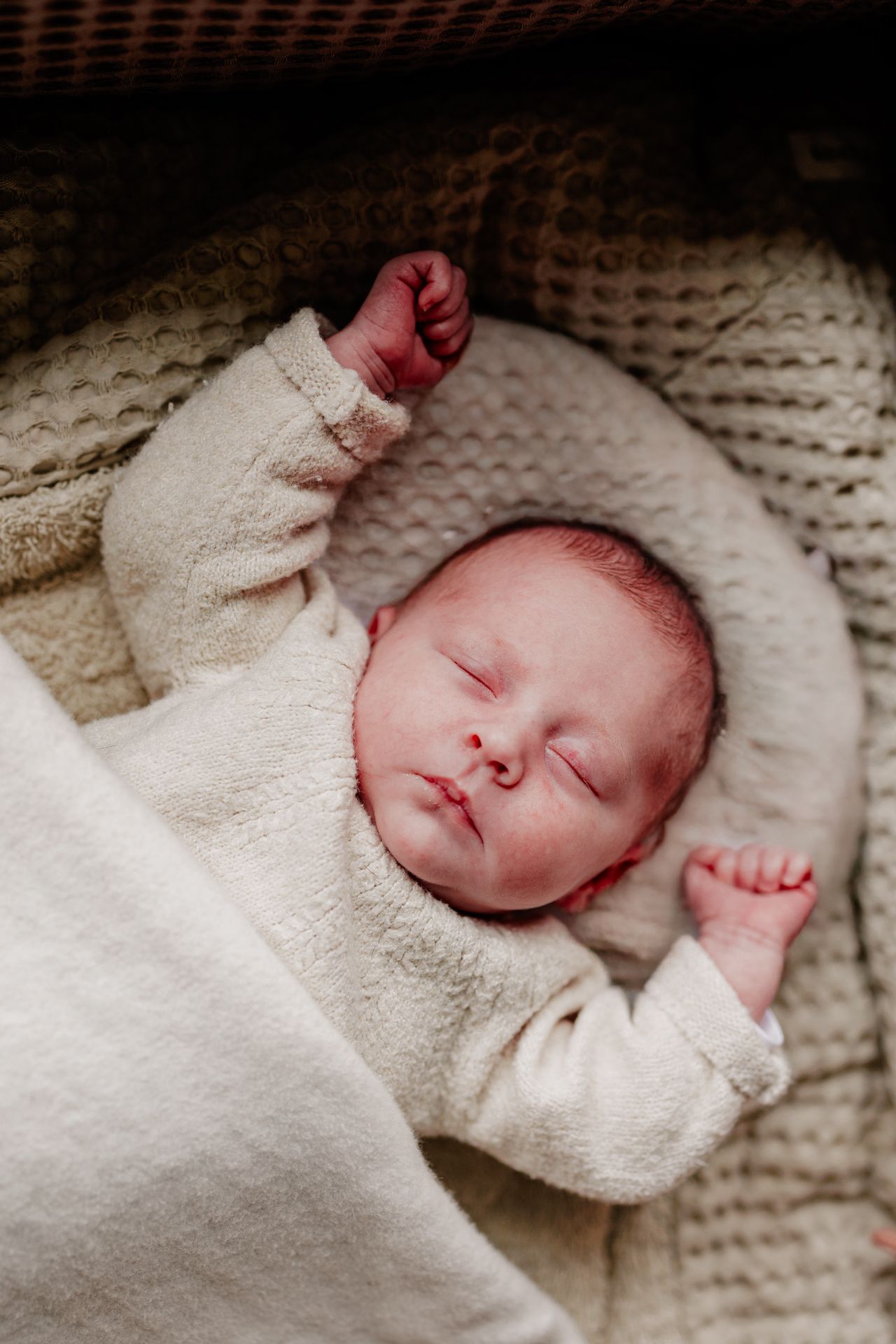 A newborn baby sleeping peacefully wrapped in a soft blanket.