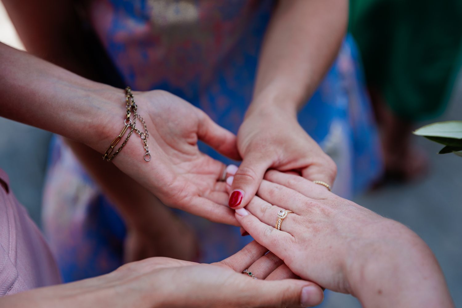 Hands of two people holding each other in a caring gesture.