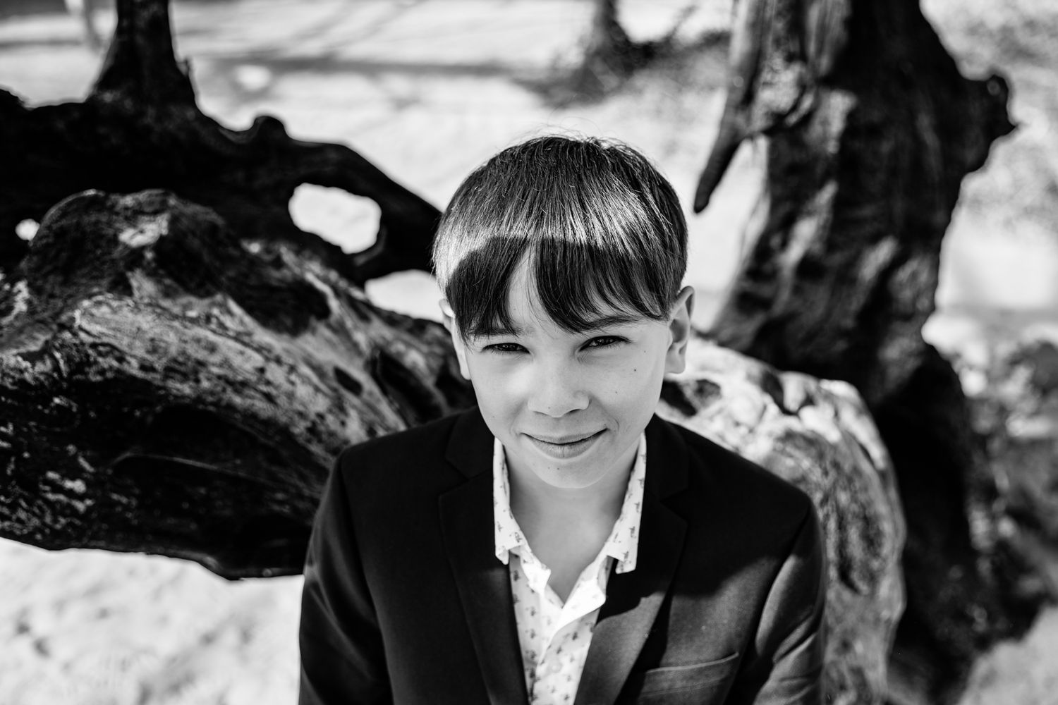 A young girl with short hair smiling at the camera in a black and white photograph.