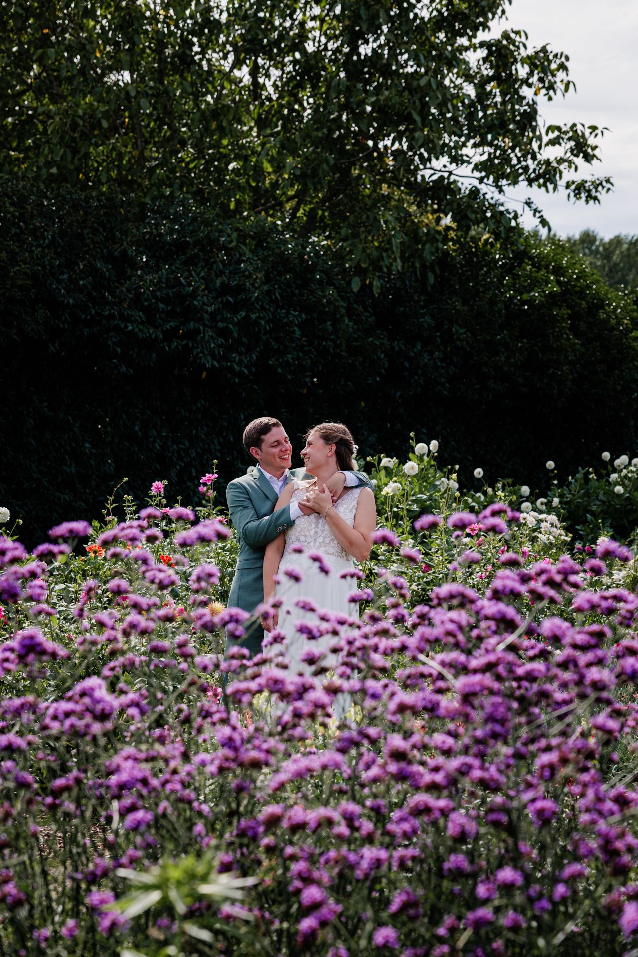 Koppel staat in een pluktuin met paarse bloemen.