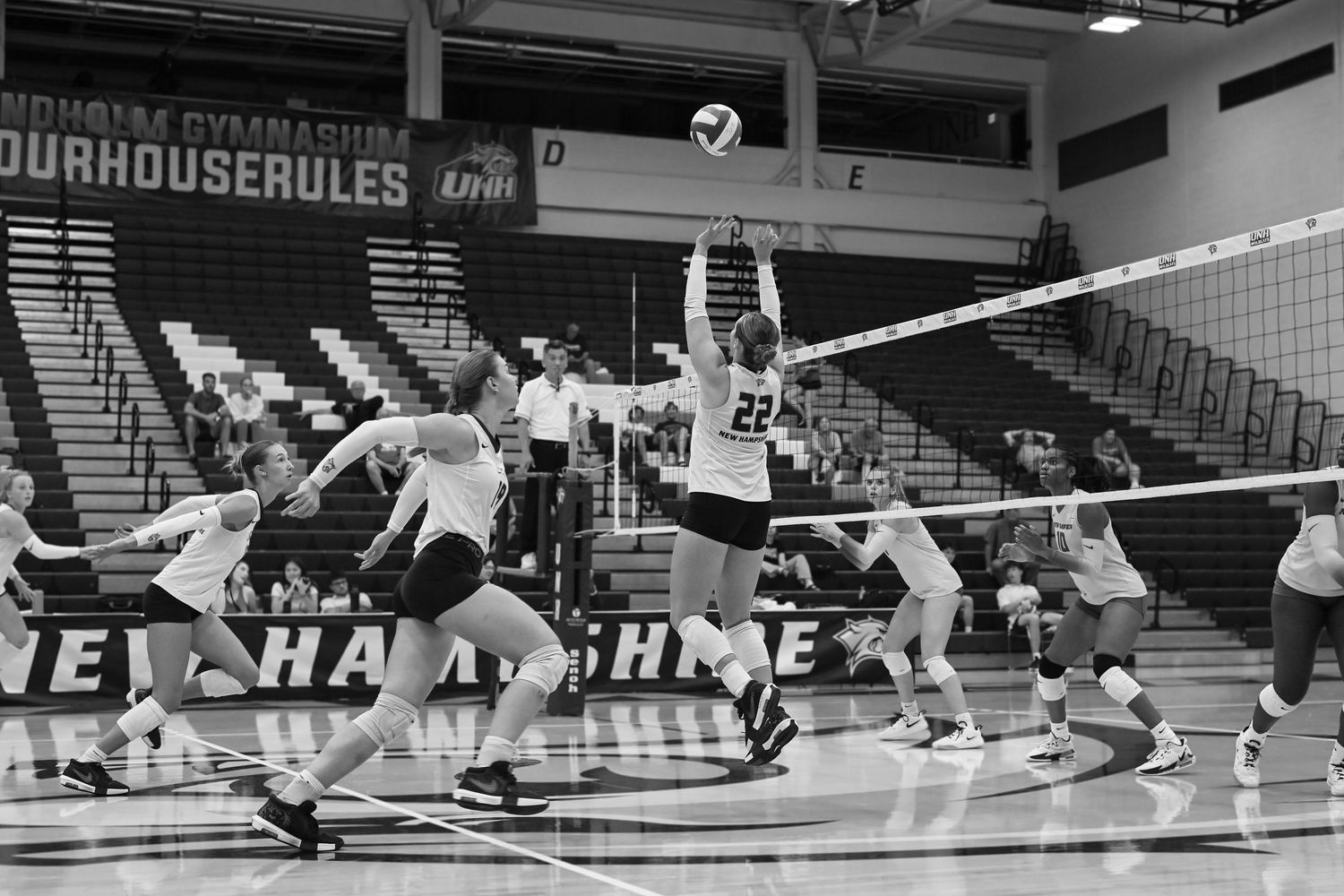 Athletes dive and stretch across the floor in a dynamic volleyball sequence showing multiple plays and movements.