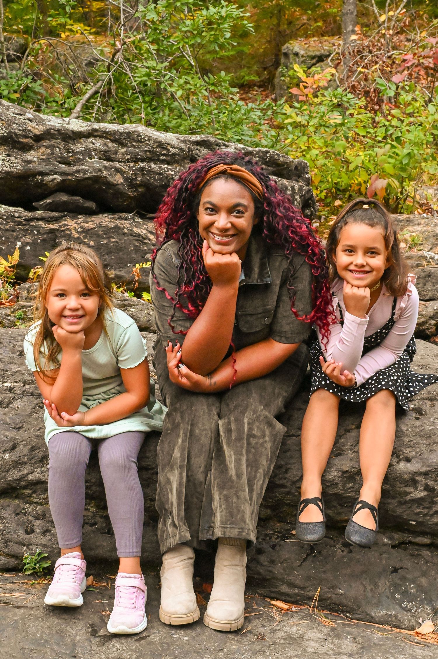 A series of photos showing children sitting on a rock ledge outdoors in autumn, displaying playful expressions and poses.
