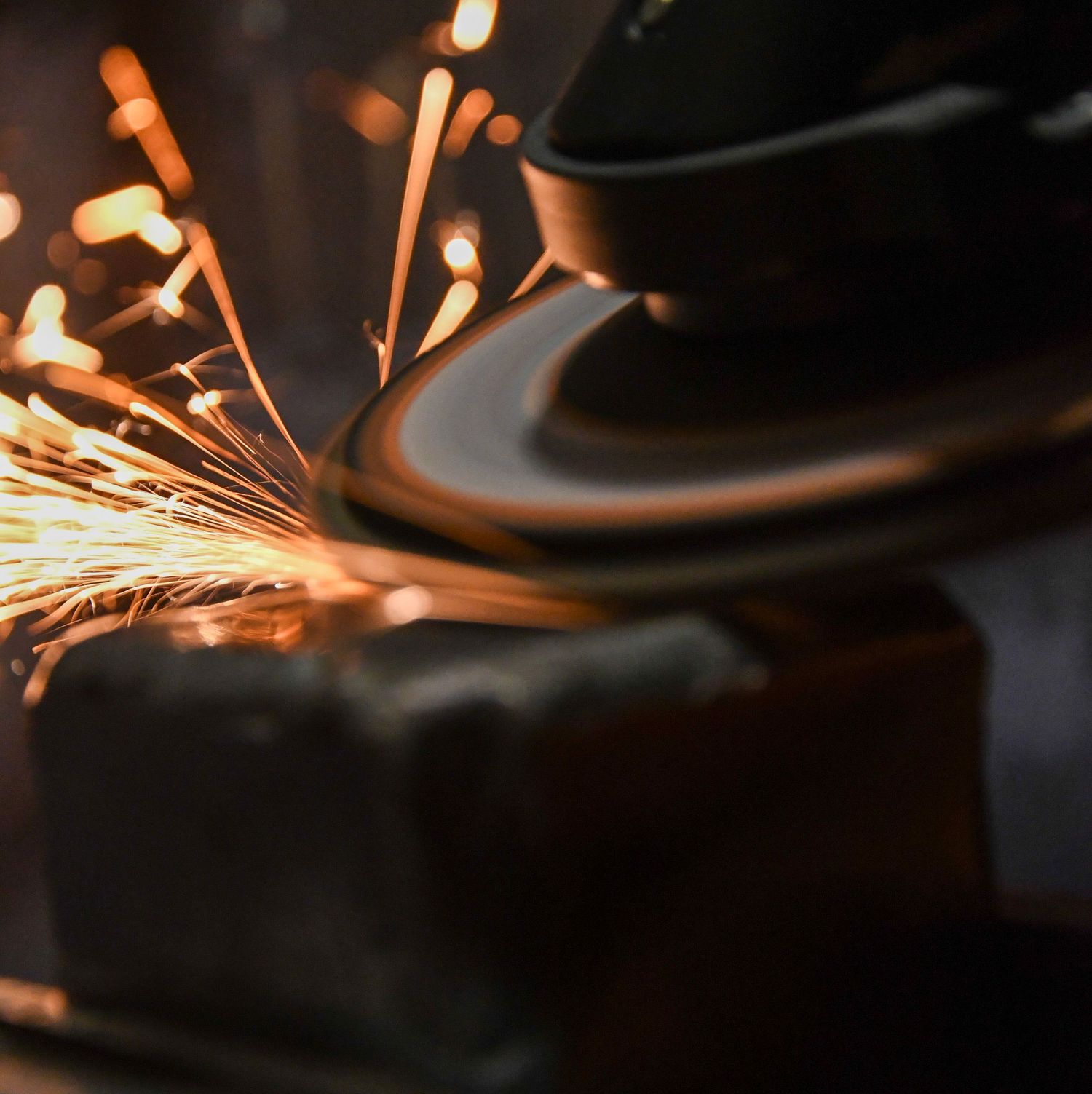 Close-up of metal grinding sparks flying during industrial metalworking process.