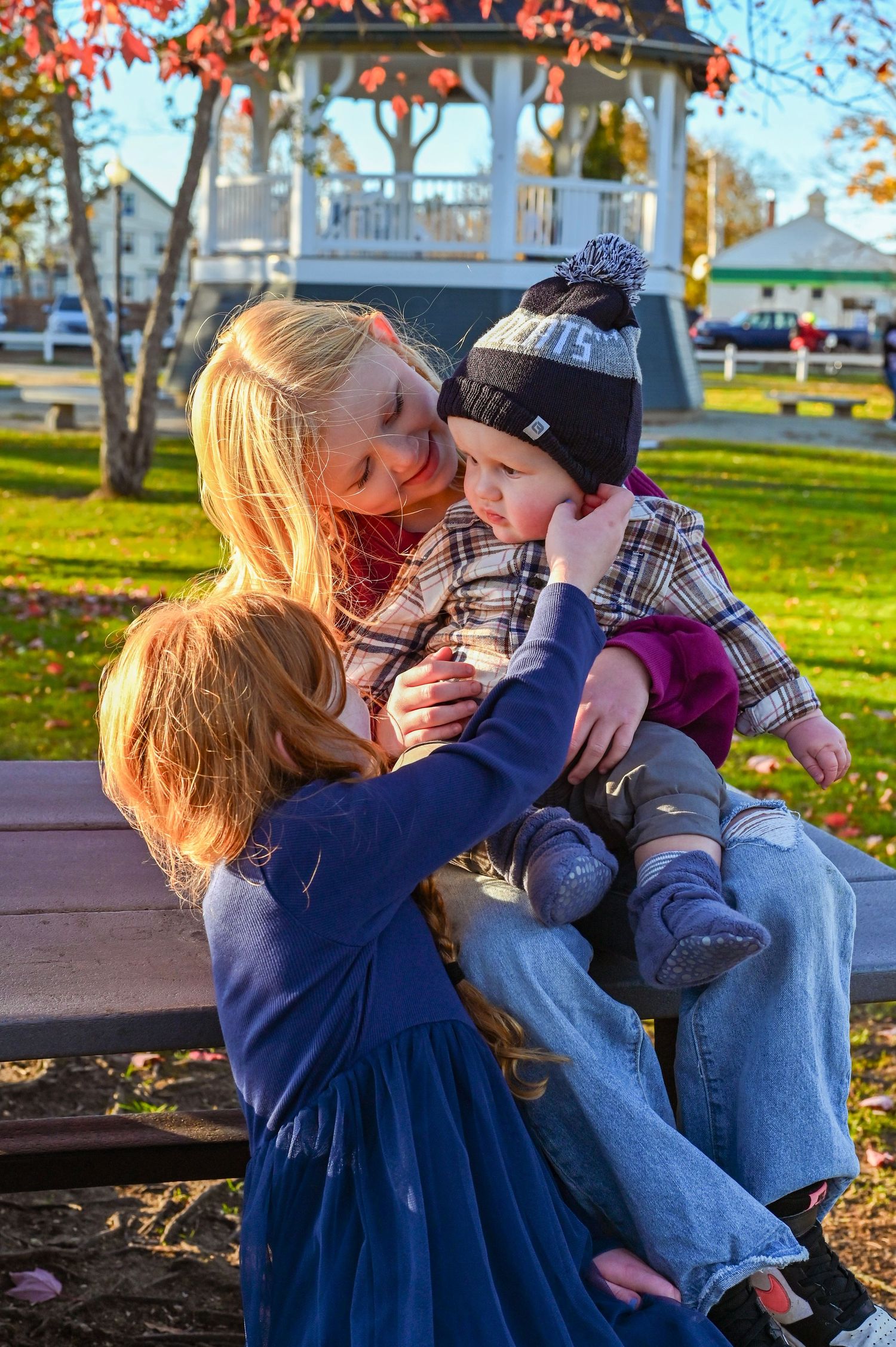 A tender moment captured in a series of photos showing affection on a park bench during autumn.