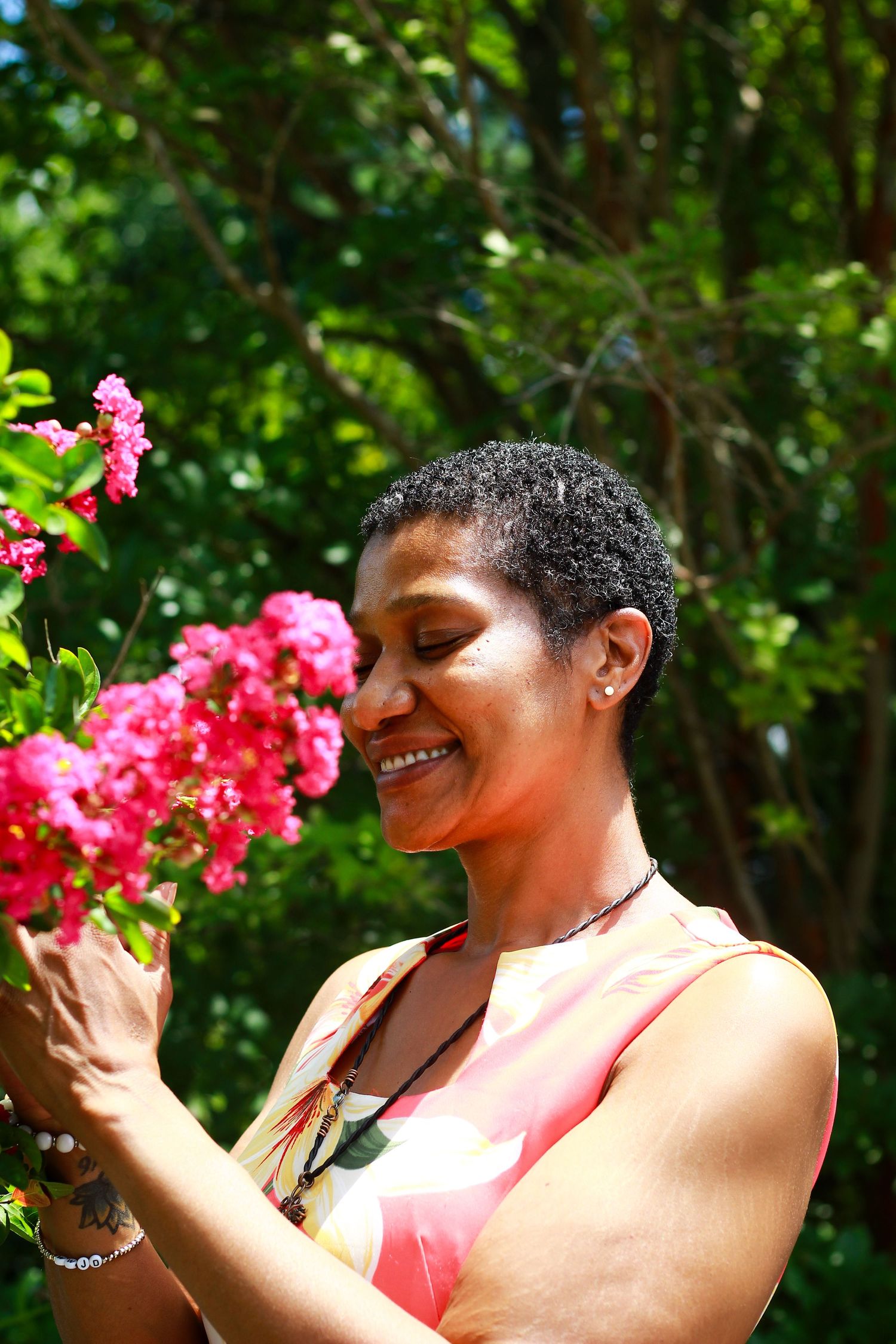 Joyful garden photoshoot with bright pink flowers against lush green foliage.