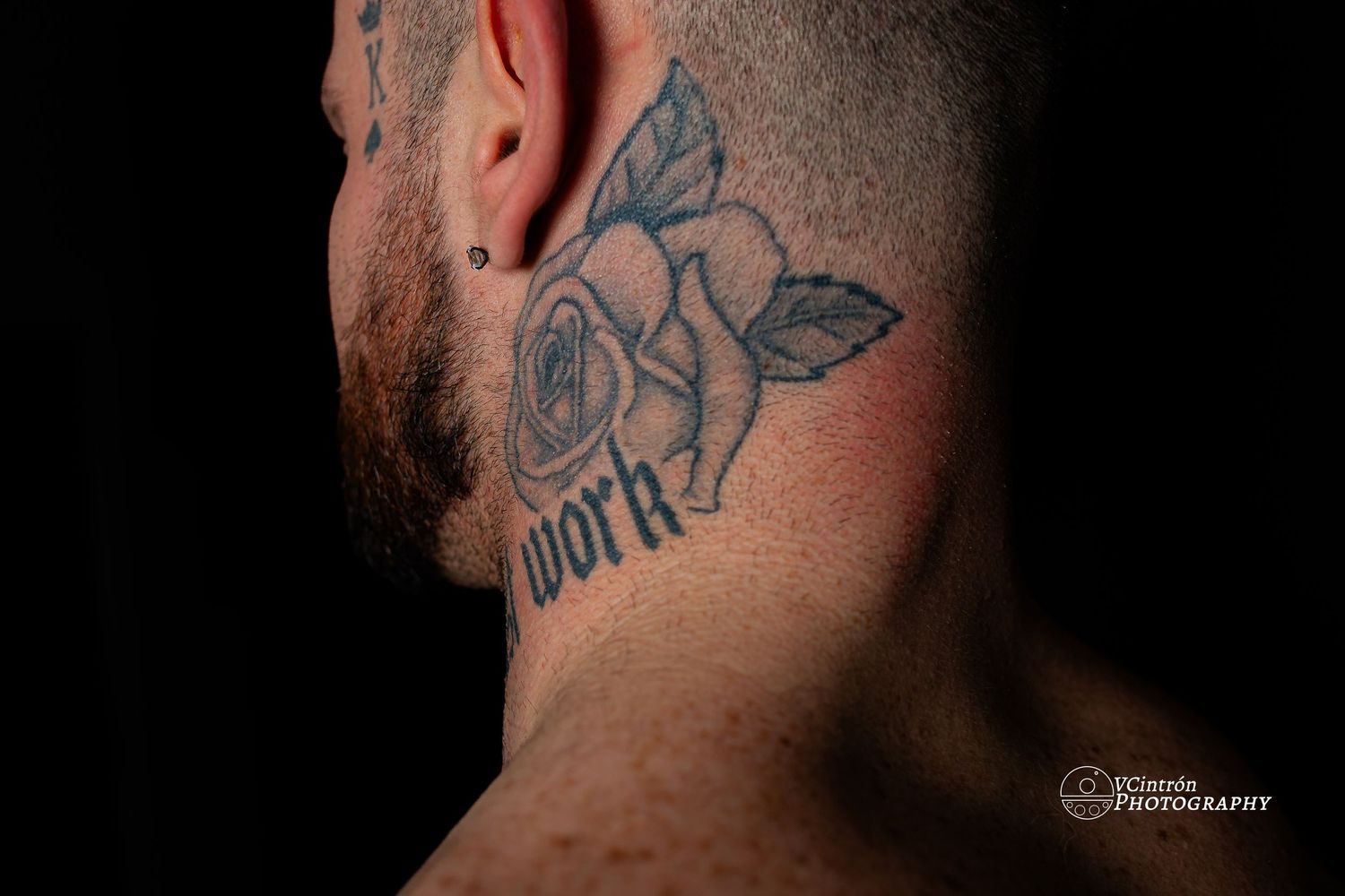 A close-up shot of a floral neck tattoo with blue rose petals and dark outlines against skin.