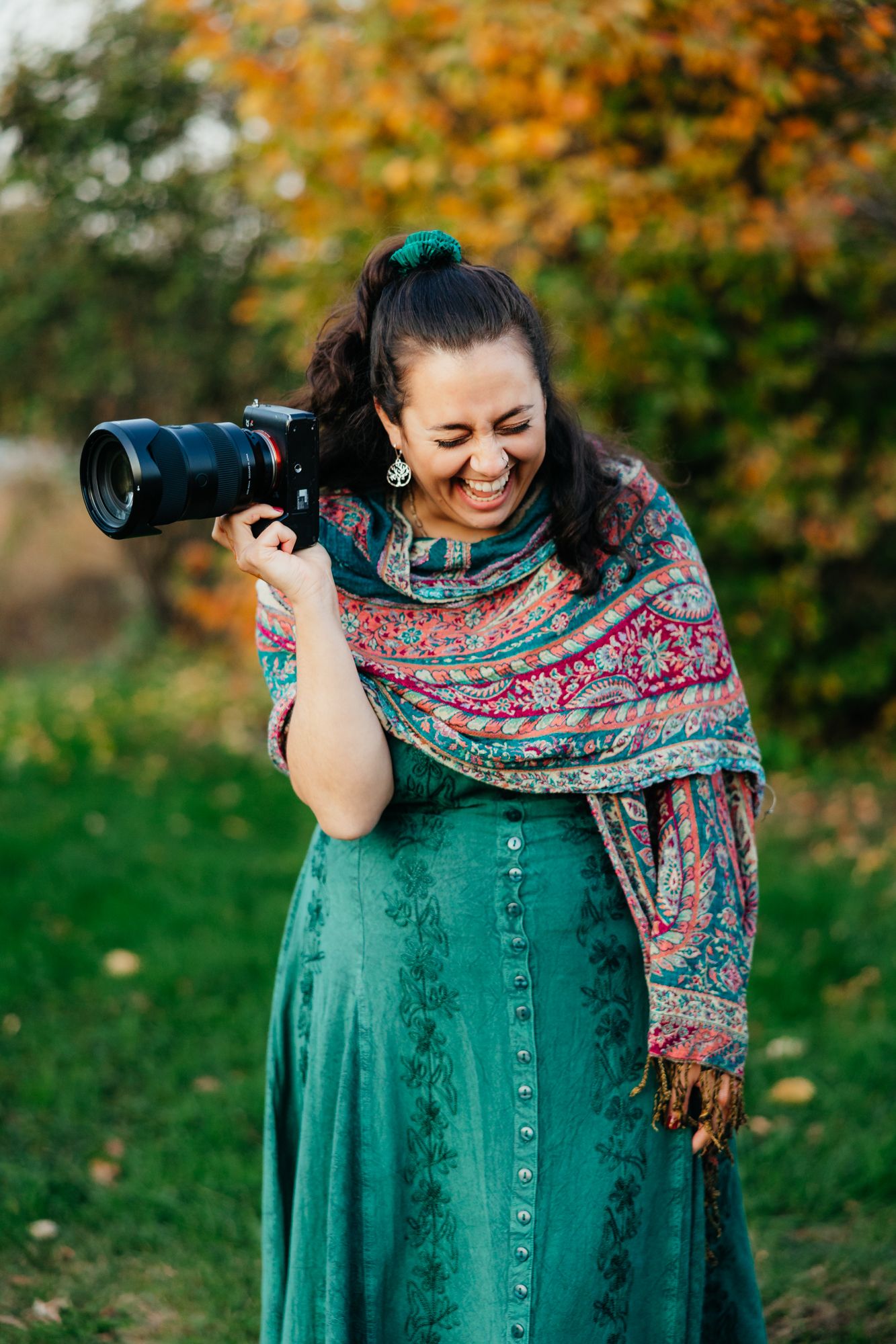 A photographer giggling with her camera in her hands